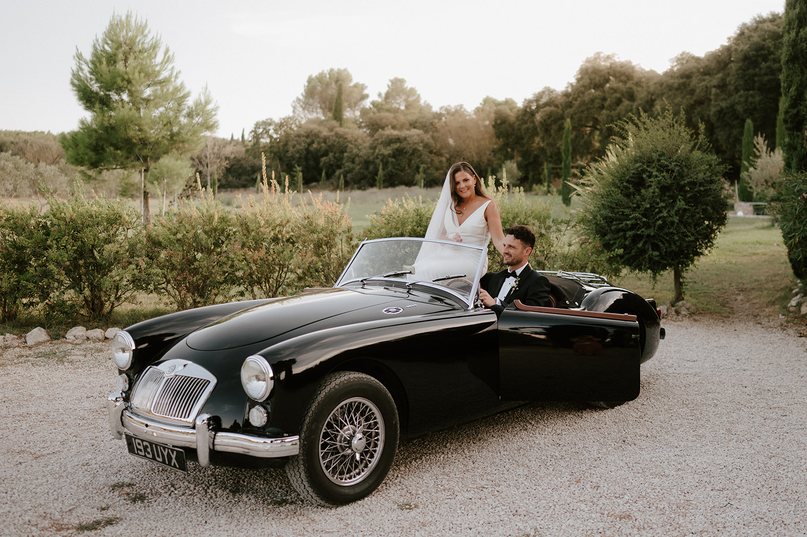 bride and groom sitting in vintage mg classic car in provence