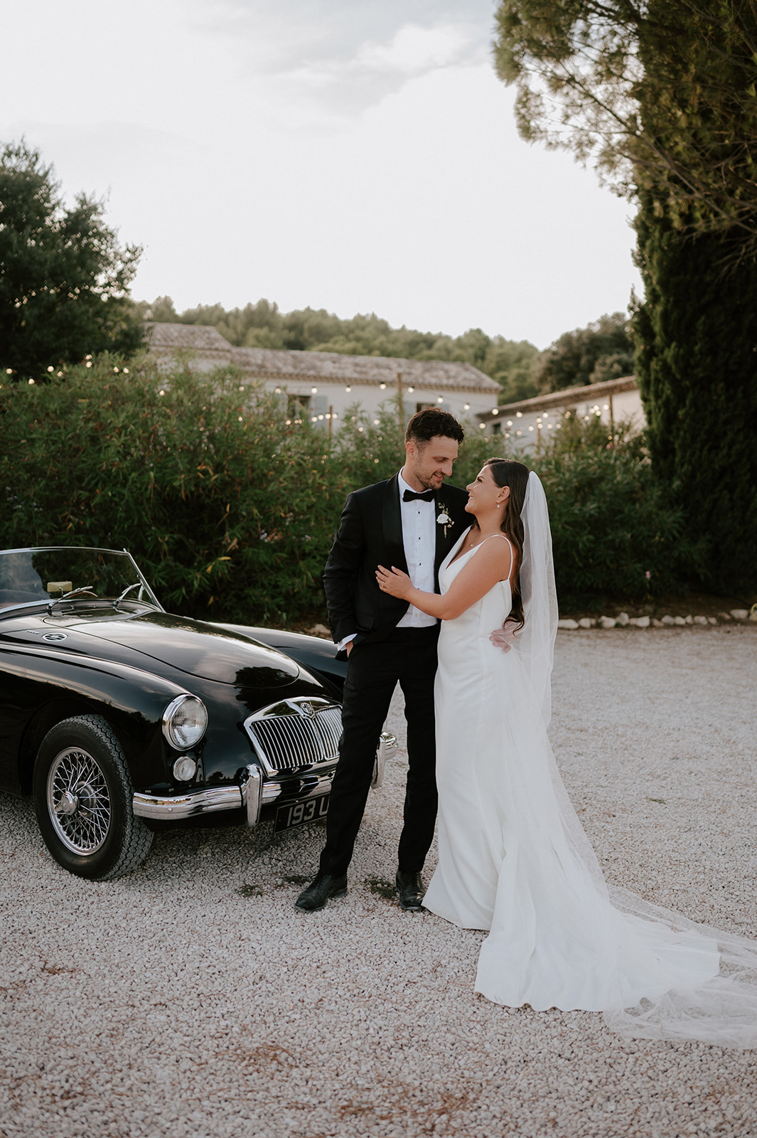 bride and groom standing by vintage mg classic car in provence