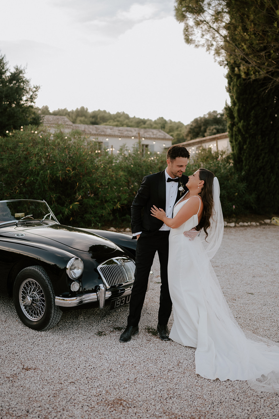 bride and groom standing by vintage mg classic car provence