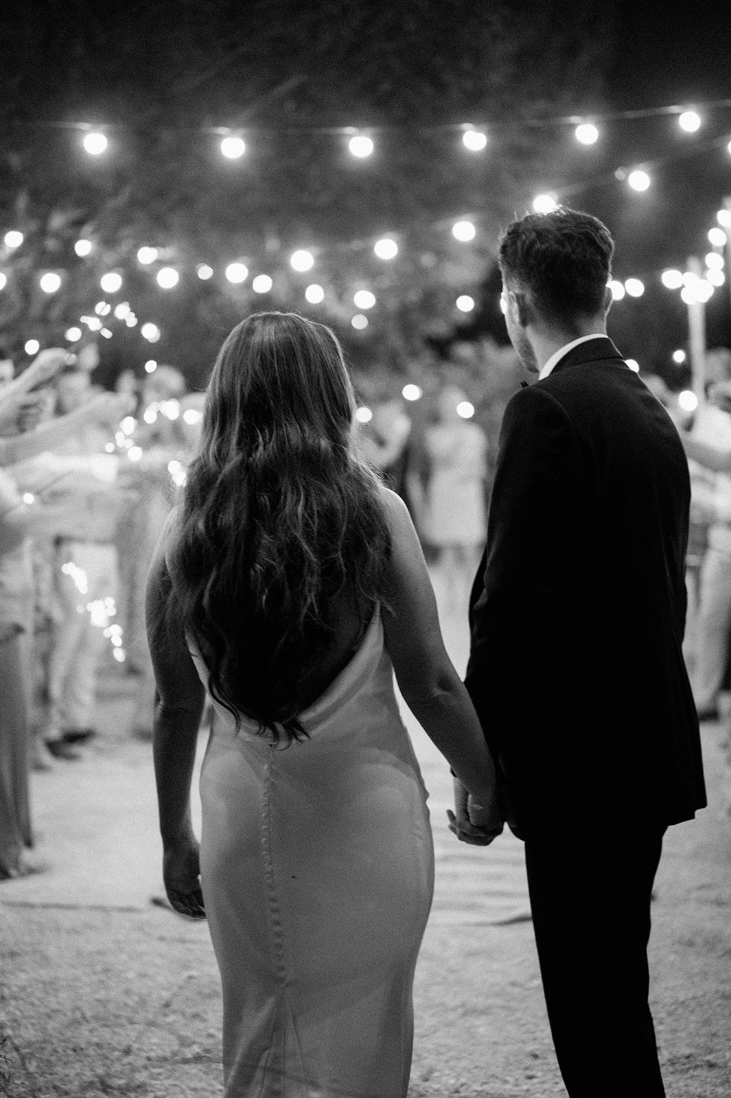 first dance outside bride and groom under festoon lights