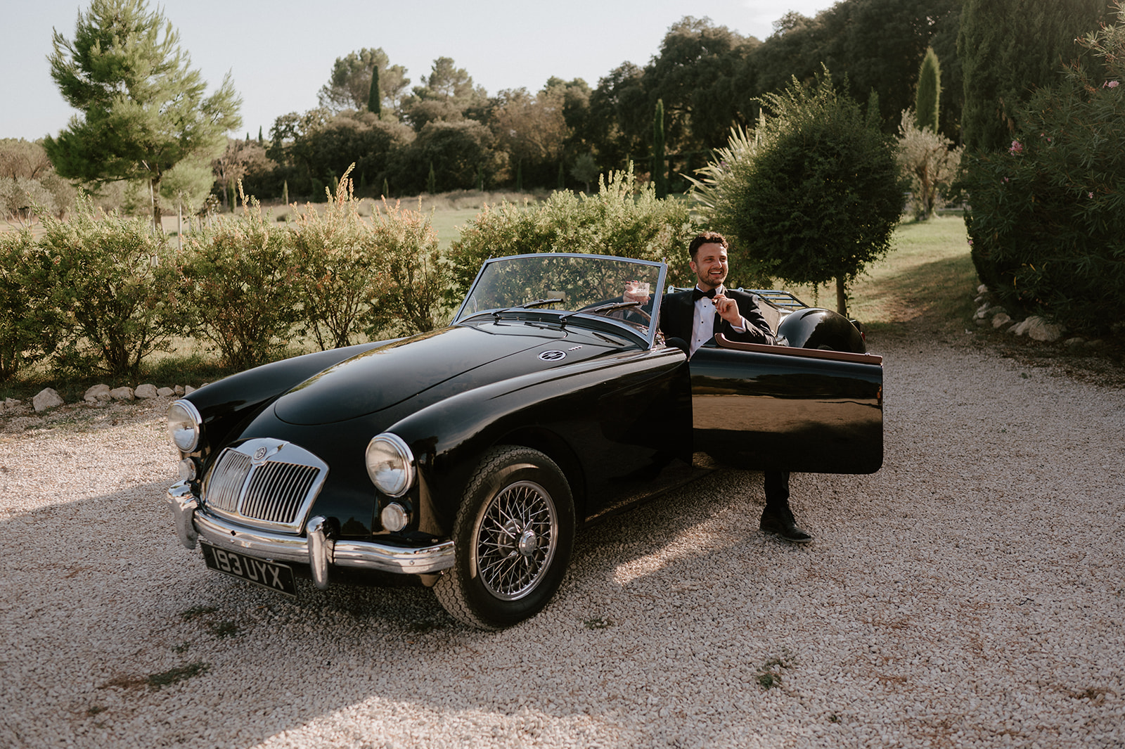 groom sitting in vintage mg classic car at Le Mas Des Costes in provence