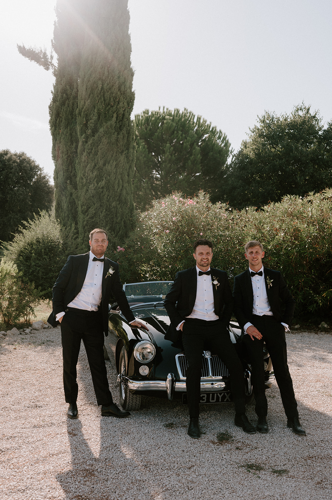 groom standing against vintage mg classic car at Le Mas Des Costes in provence