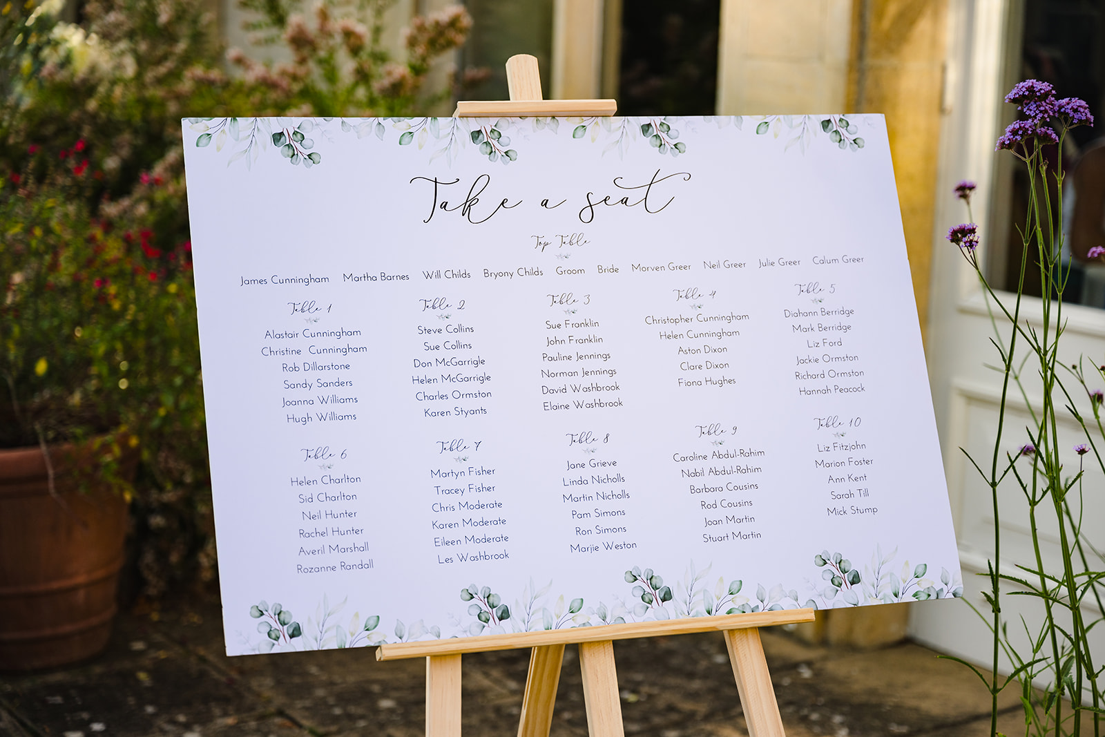wedding table plan with white background and green florals