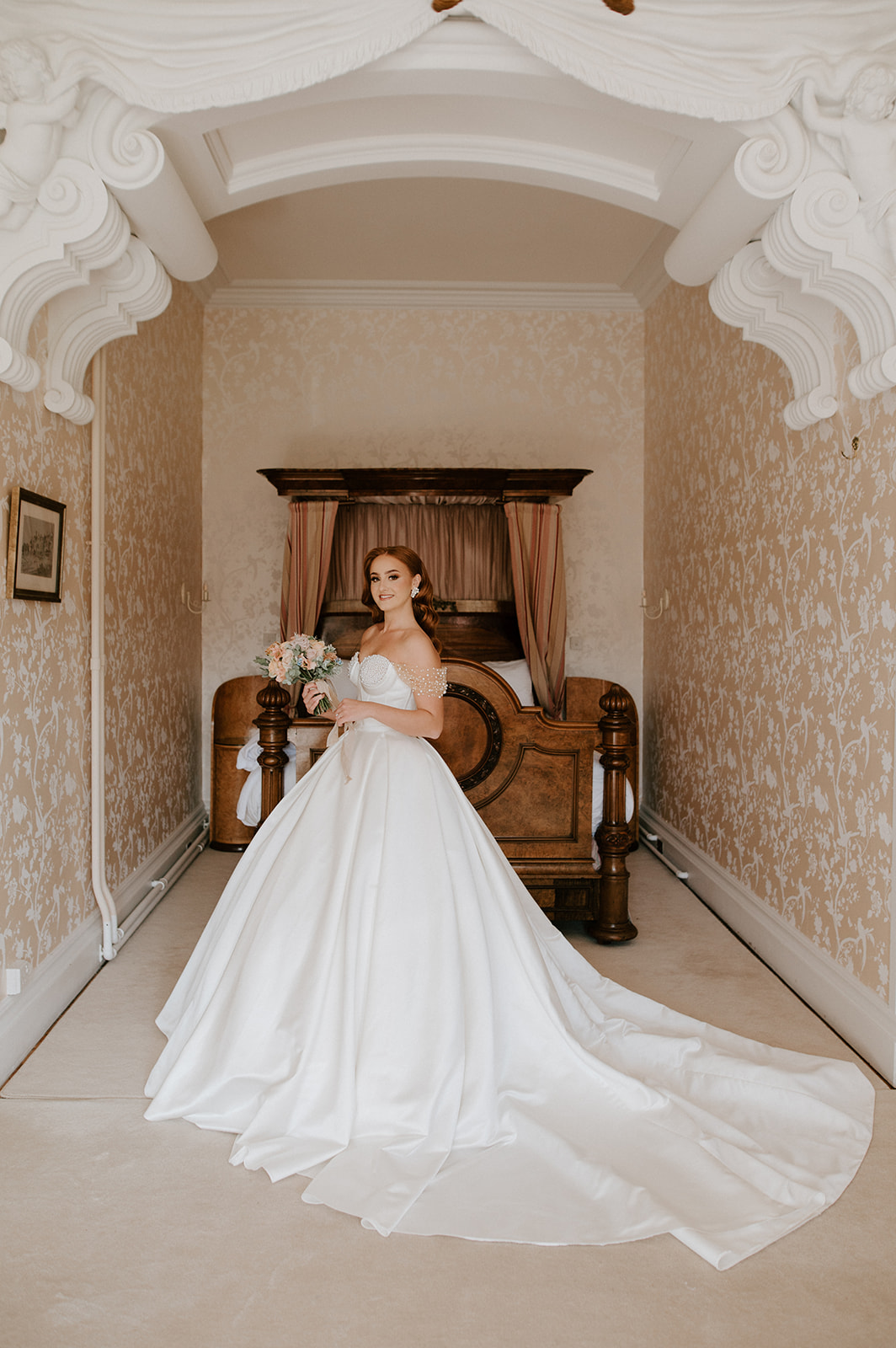 bride in bridal suite at harlaxton manor holding bouquet of flowers