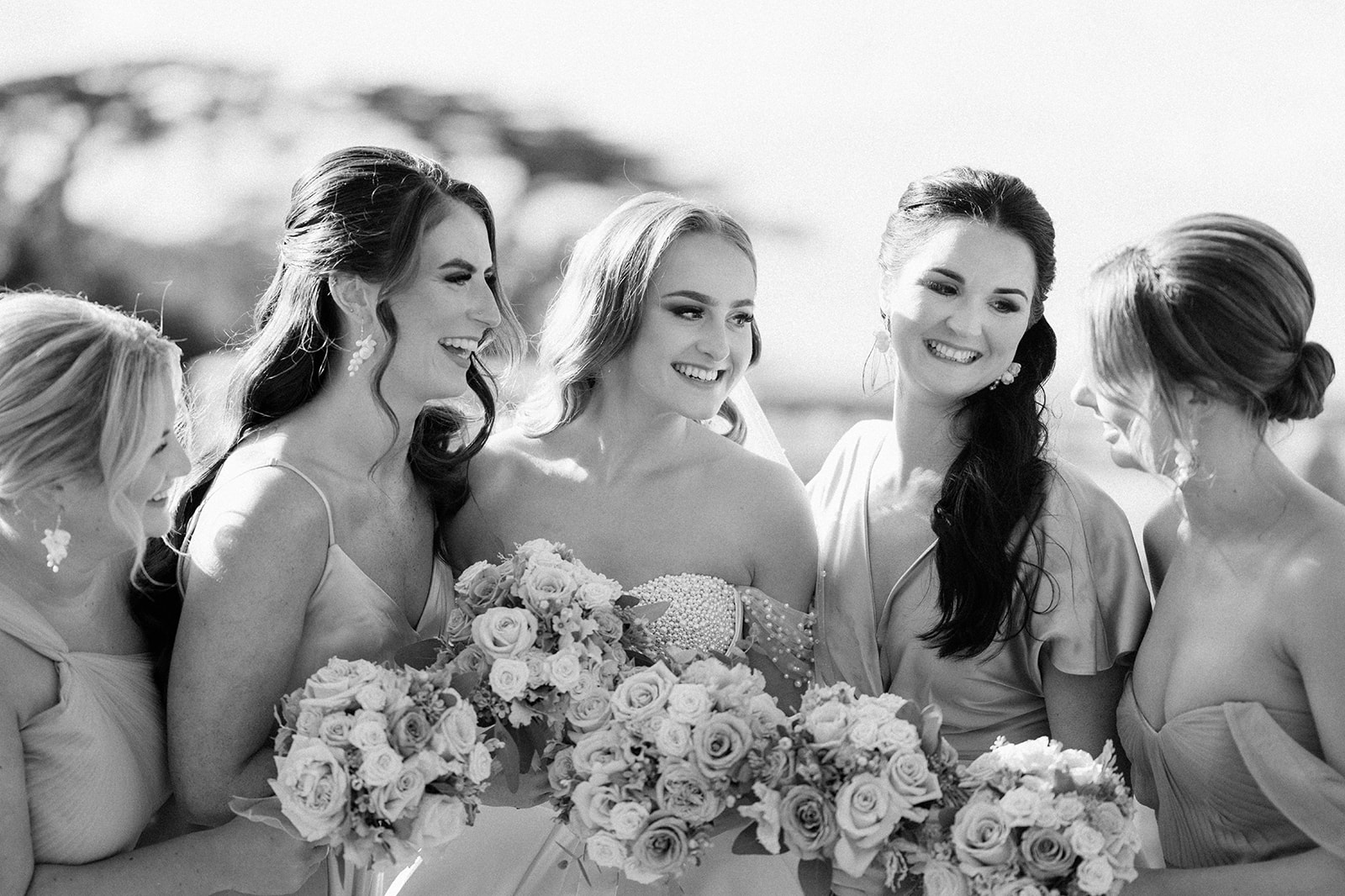 bride and bridesmaids smiling and laughing