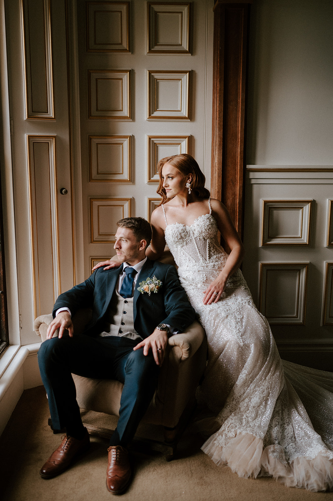 bride and groom sitting down looking out of window at harlaxton manor