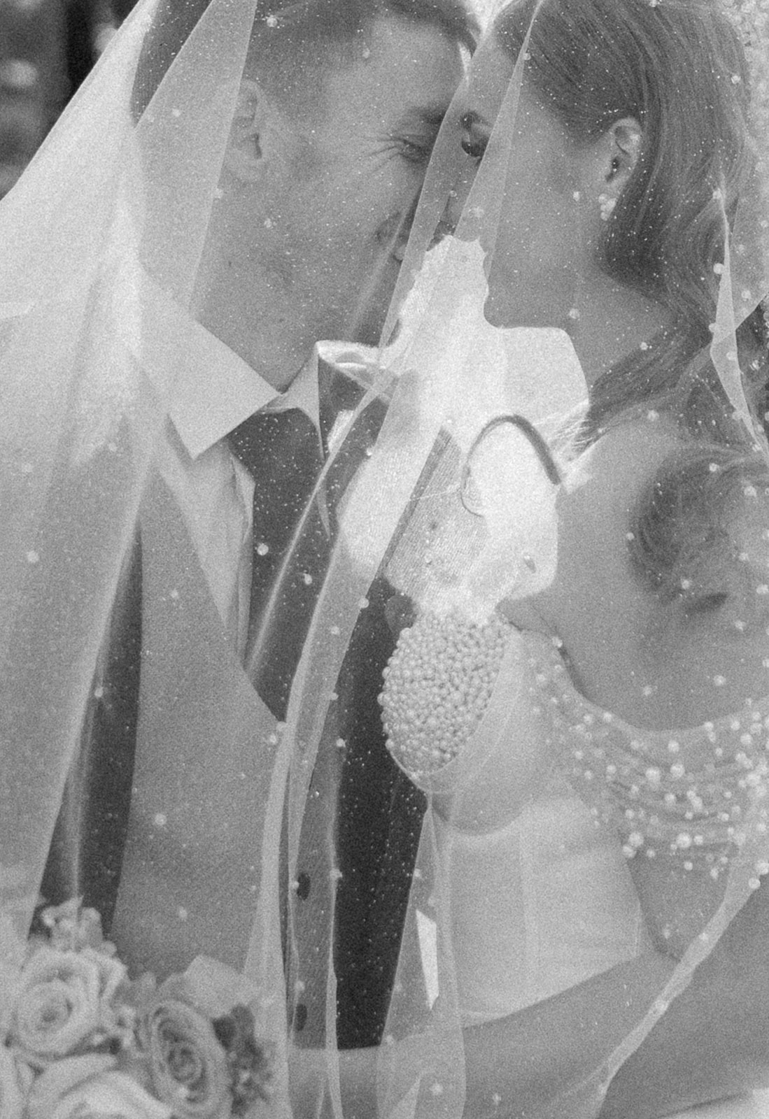 bride and groom under sparkly veil