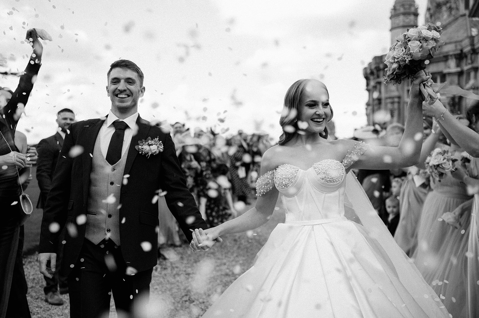 bride and groom walking through confetti tunnel