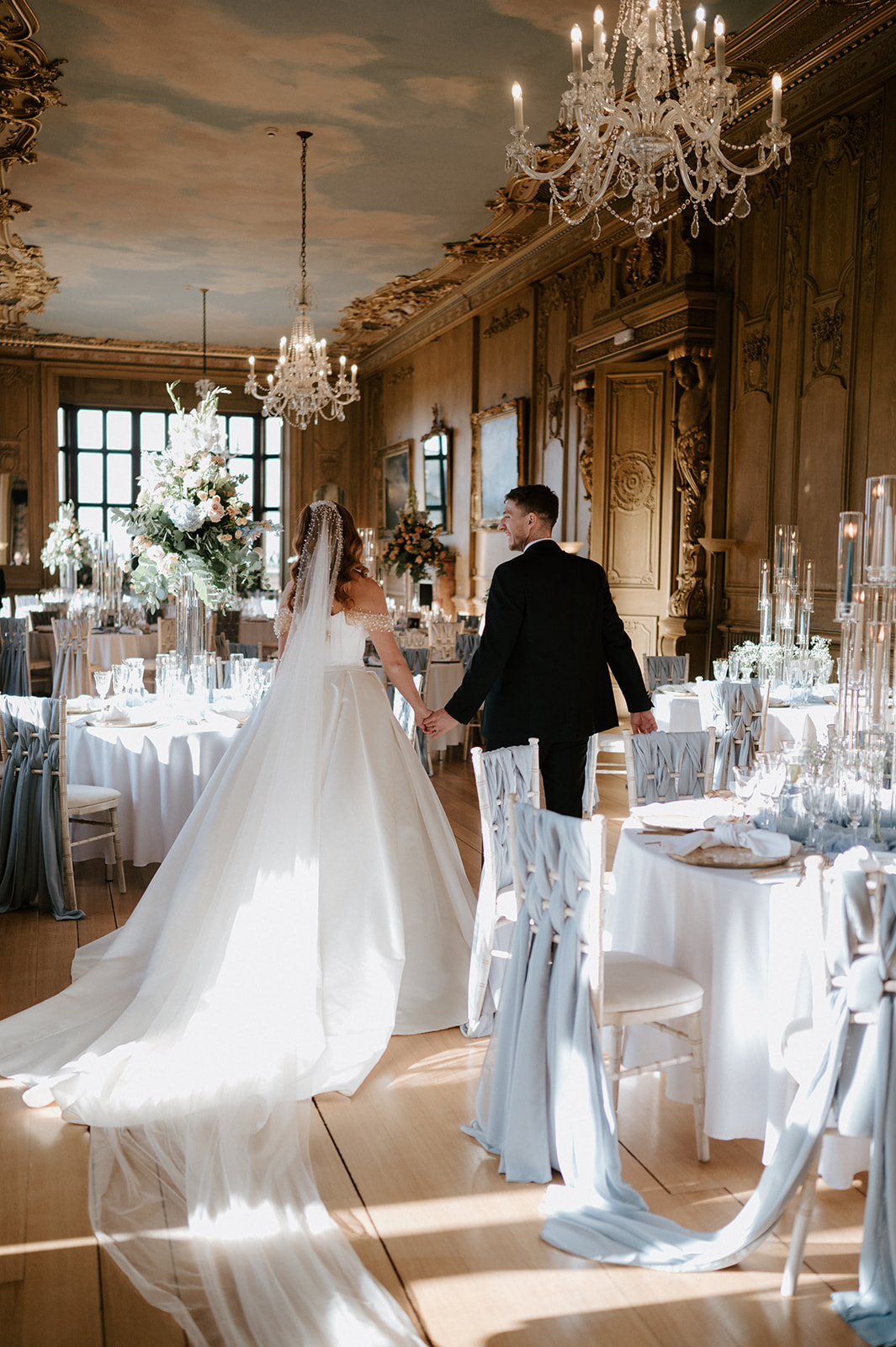 bride and groom walking through the long gallery at harlaxton manor
