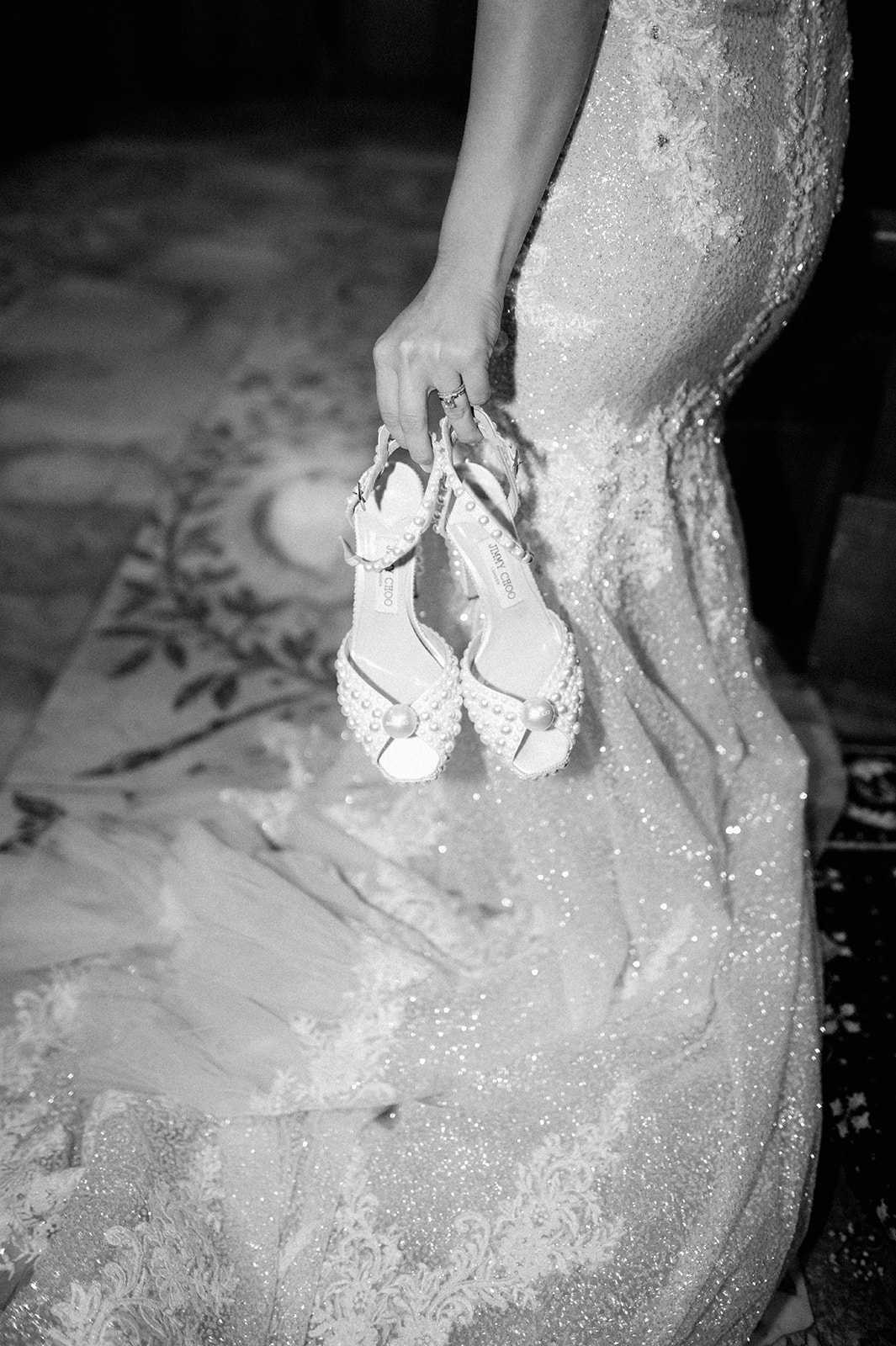 bride holding jimmy choo shoes with pearls