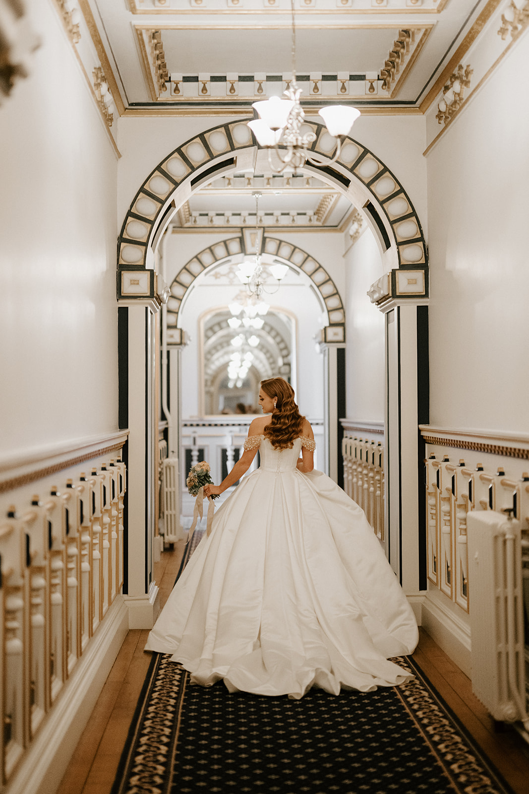 bride walking down regal hallway