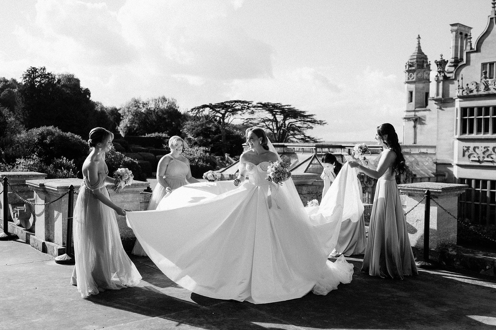 bridesmaids adjusting bride's dress