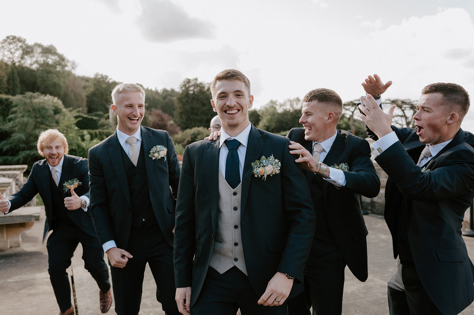 groom with groomsmen standing outside harlaxton manor