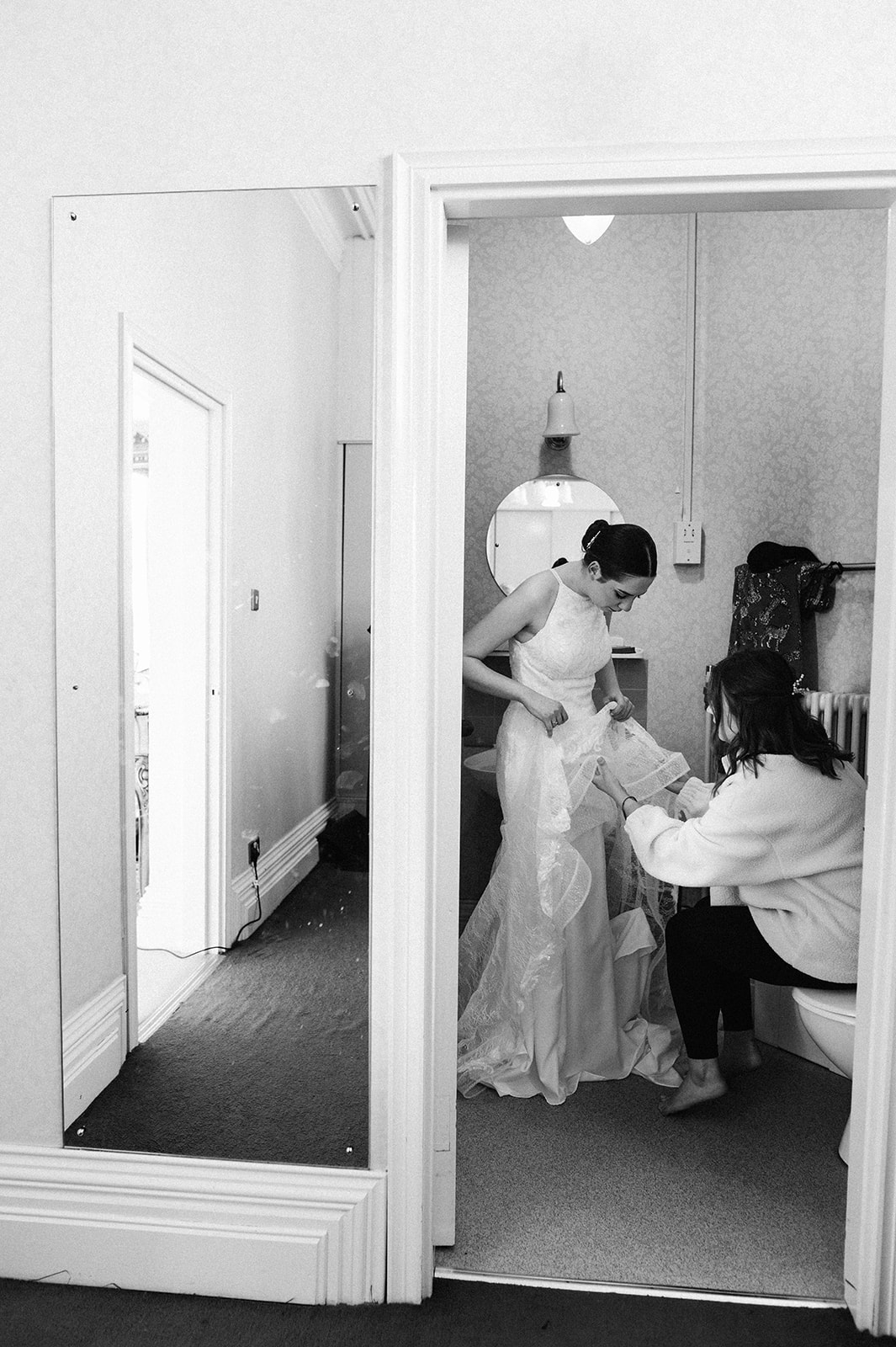 The bride getting dressed in the bathroom at Highbury Hall