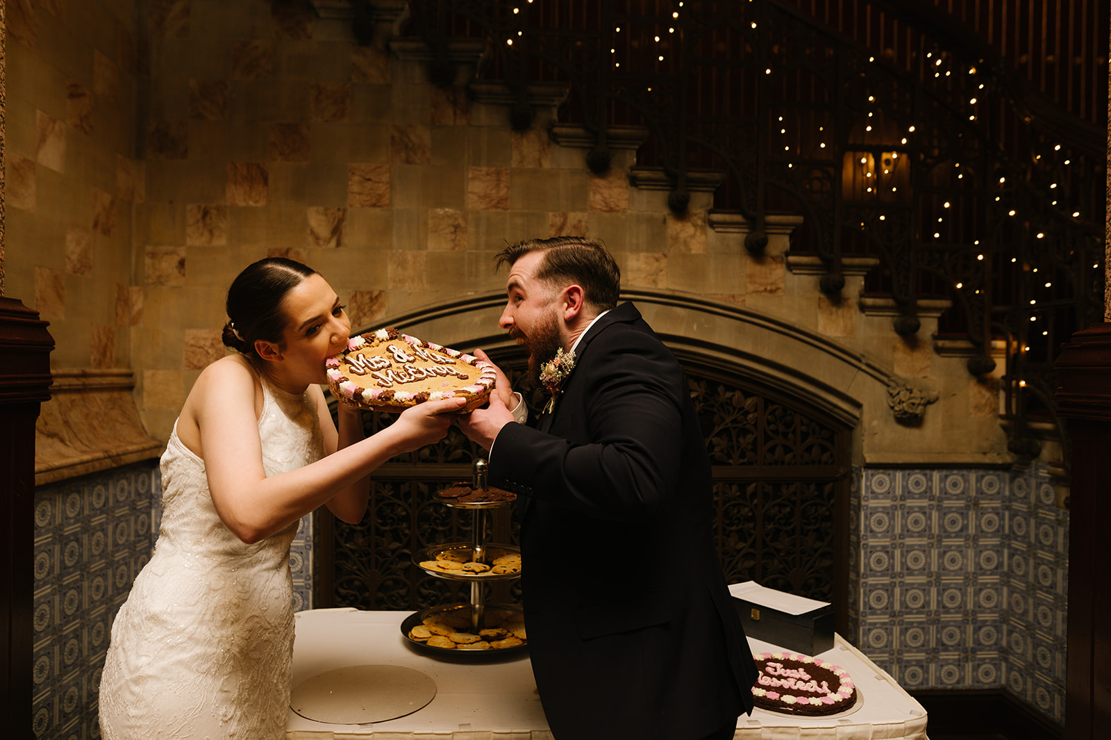 The bride and groom take a bite from their wedding cookie