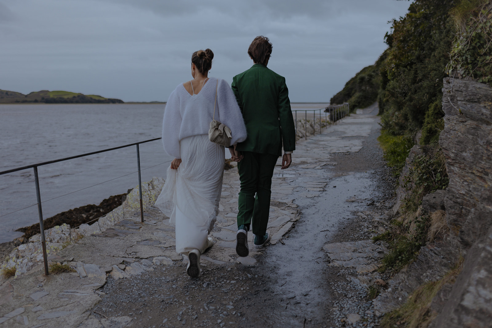 bride and groom walking by the sea at sunset at Frances quinn wedding in wales