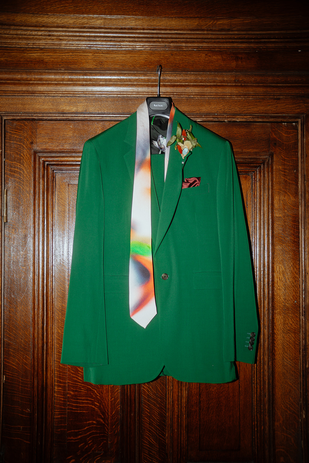 The grooms green paul smith suit jacket hanging up 