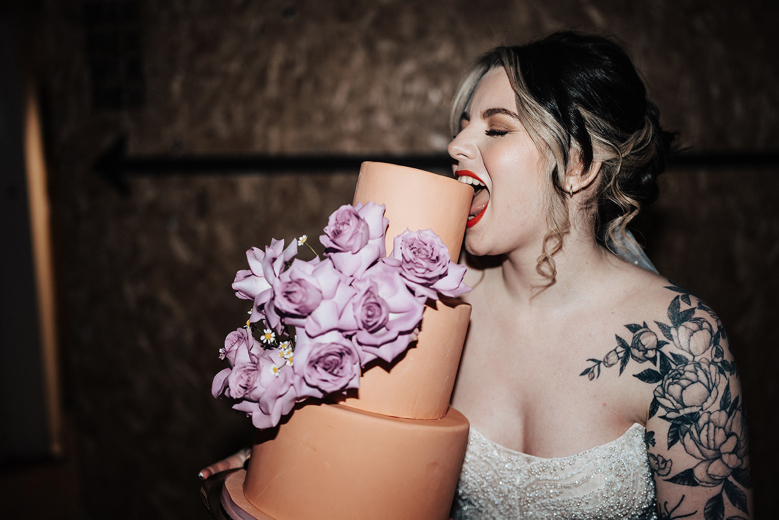 bride eats cake with purple roses  | Chocolate Factory Wedding Derby