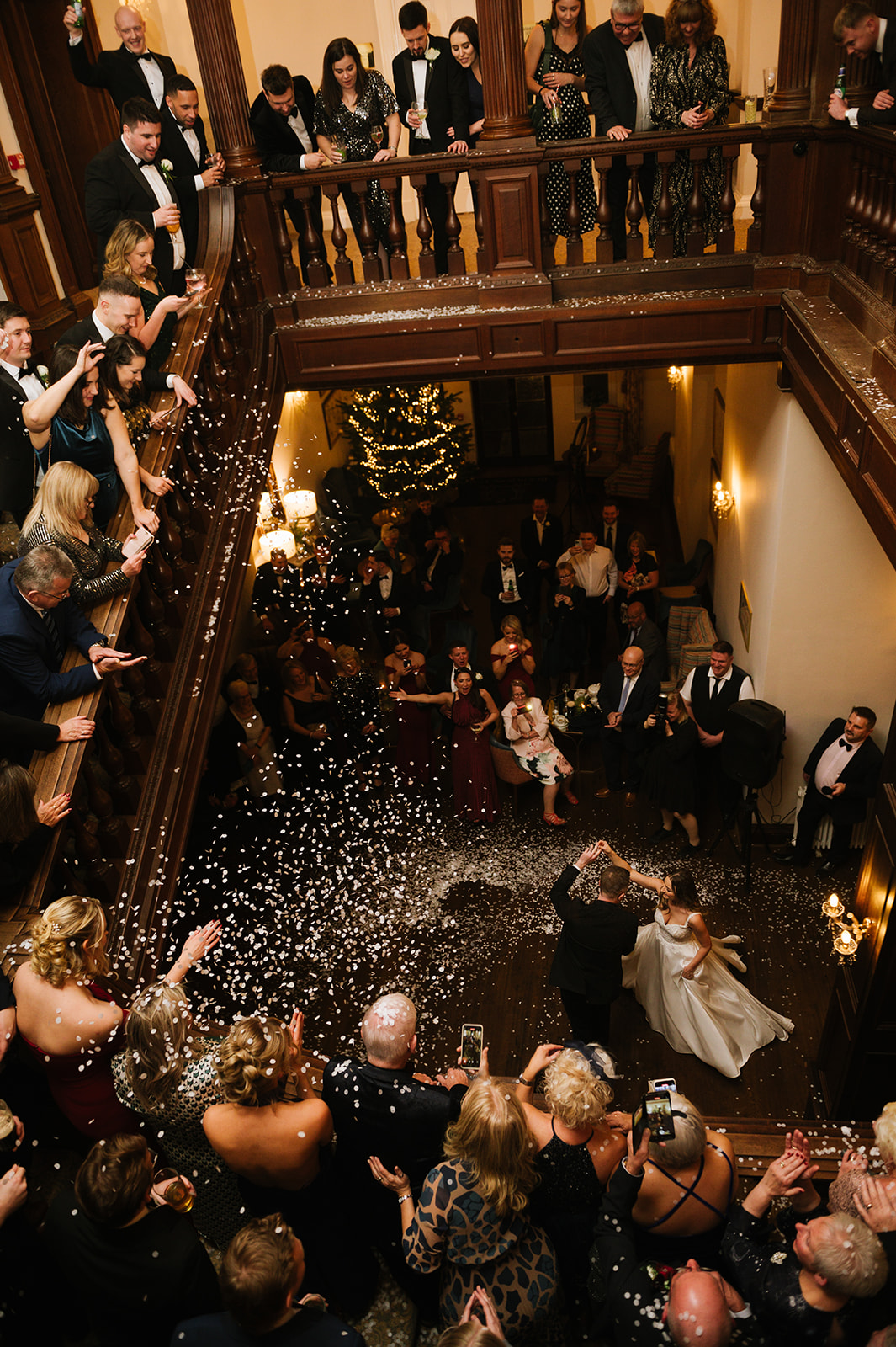 the bride and groom take have their first dance with guests watching from the staircase of Bourton Hall