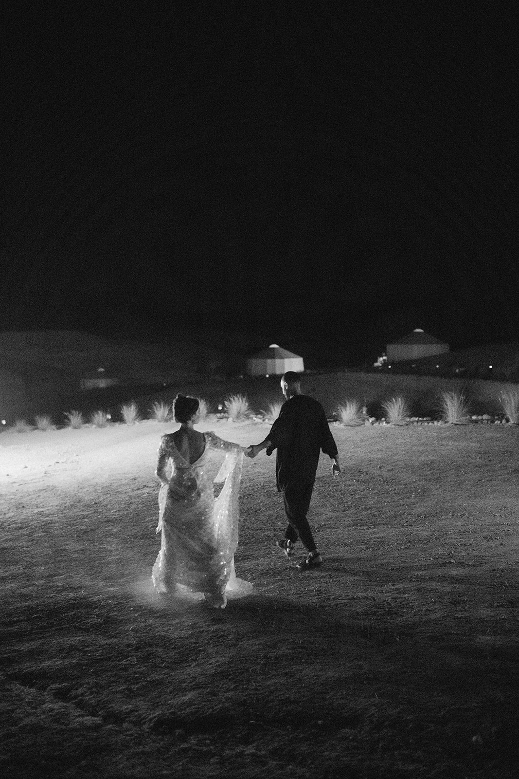 bride and groom walking to fire show in agafay desert