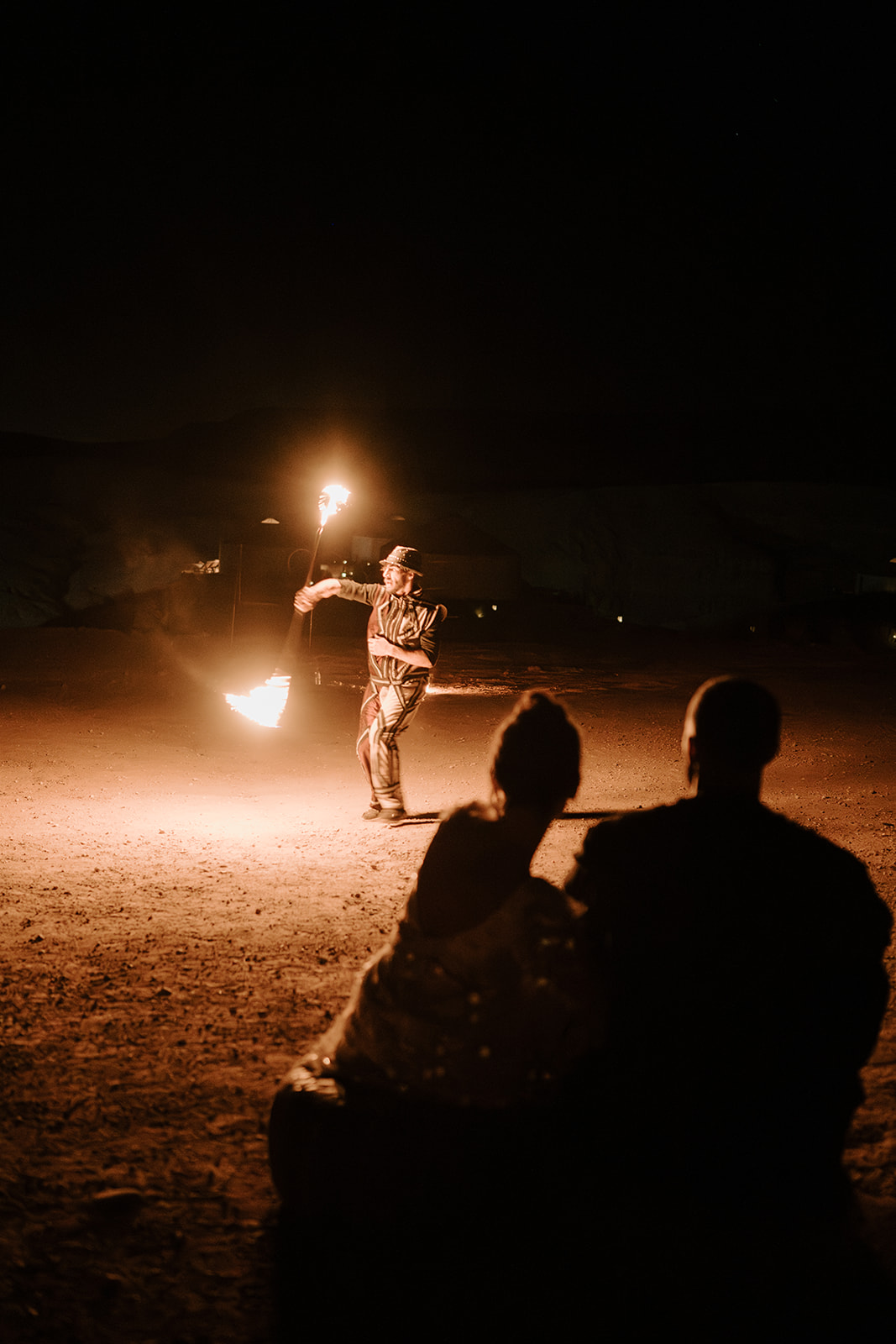 bride and groom watching fire show in agafay desert