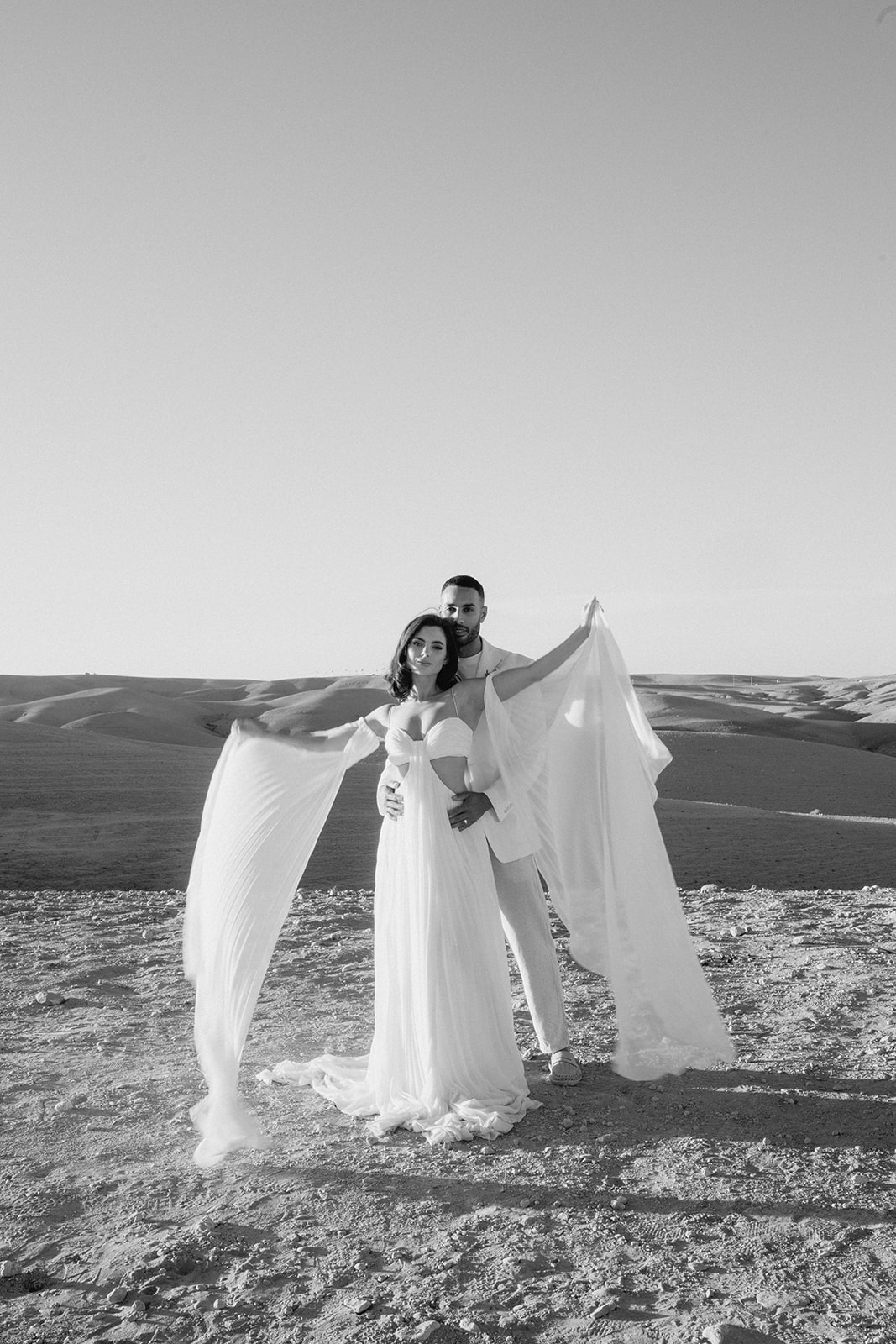 bride with white wedding dress standing with groom in agafay desert wedding elopement 