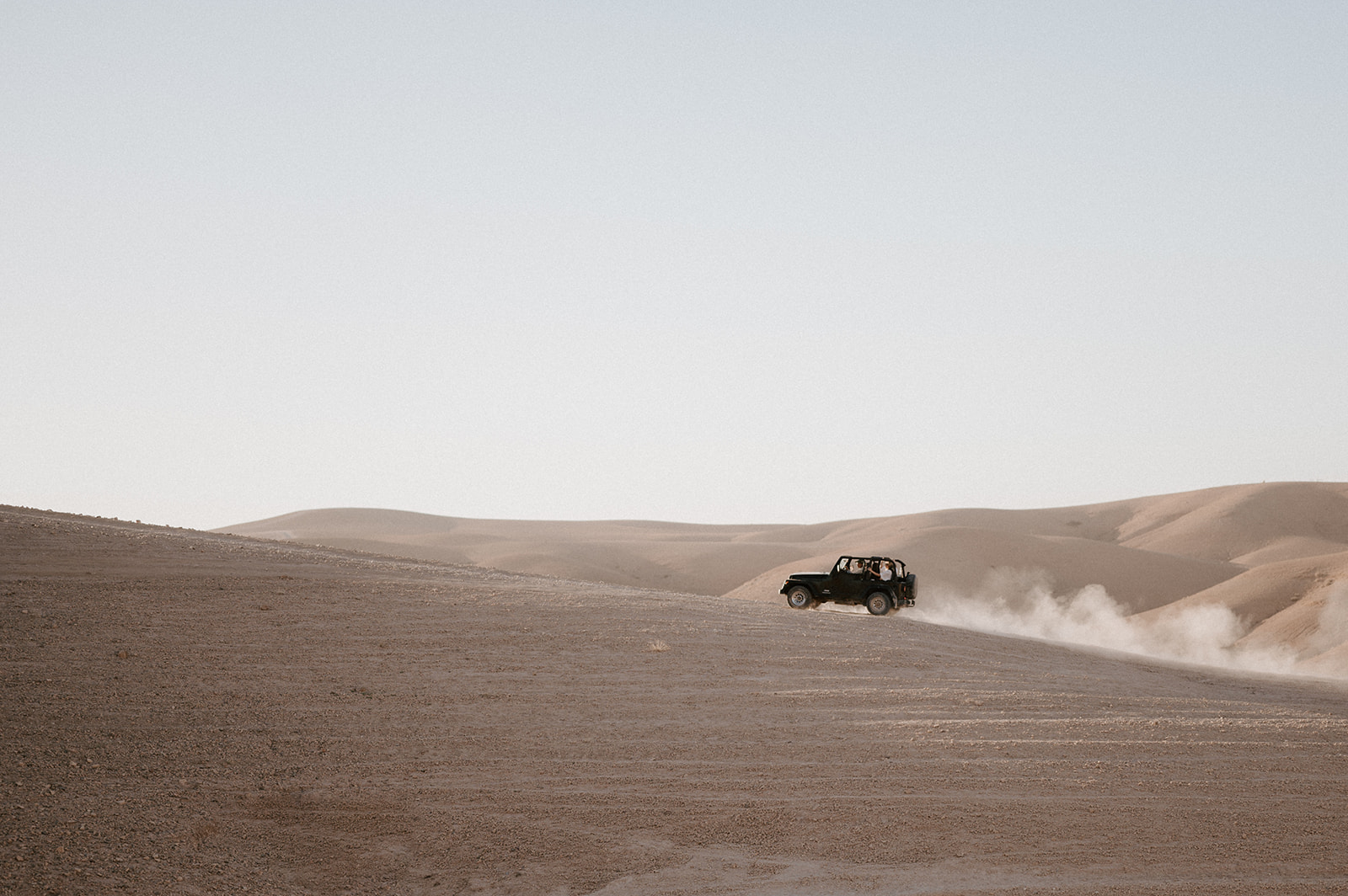 druck driving up sand dune in agafay desert 