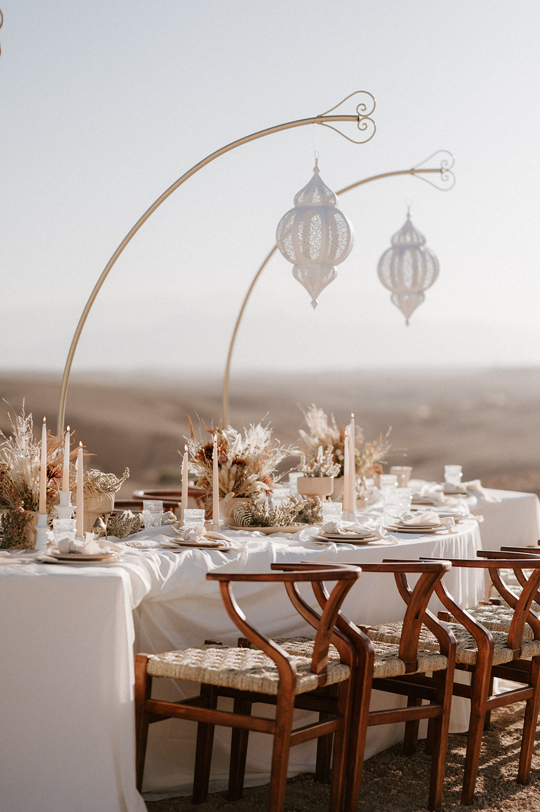 wedding breakfast set up with hanging lanterns on sand dune at Be Agafay Marrakesh 