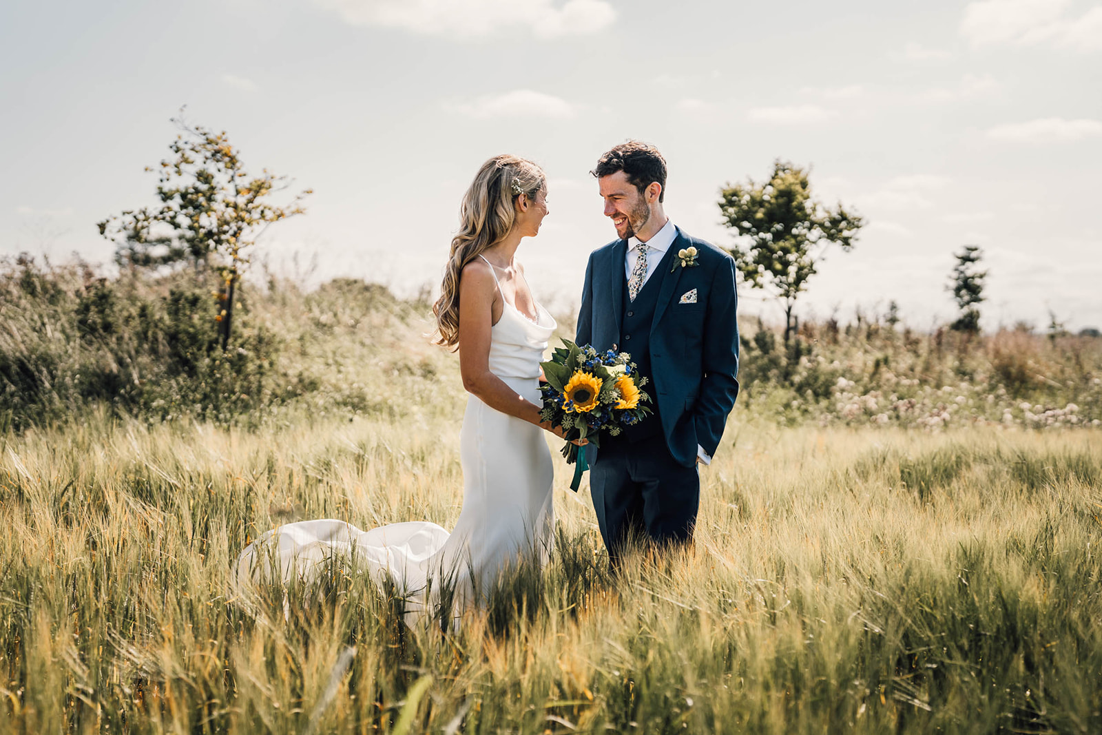 bride and groom standing in a field