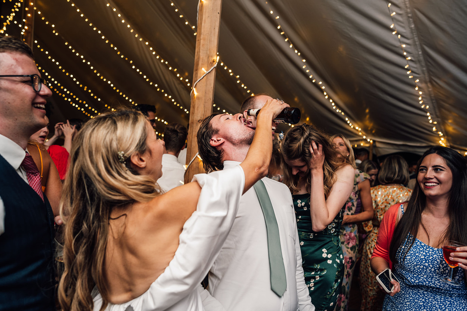 bride pouring drink into a guests mouth