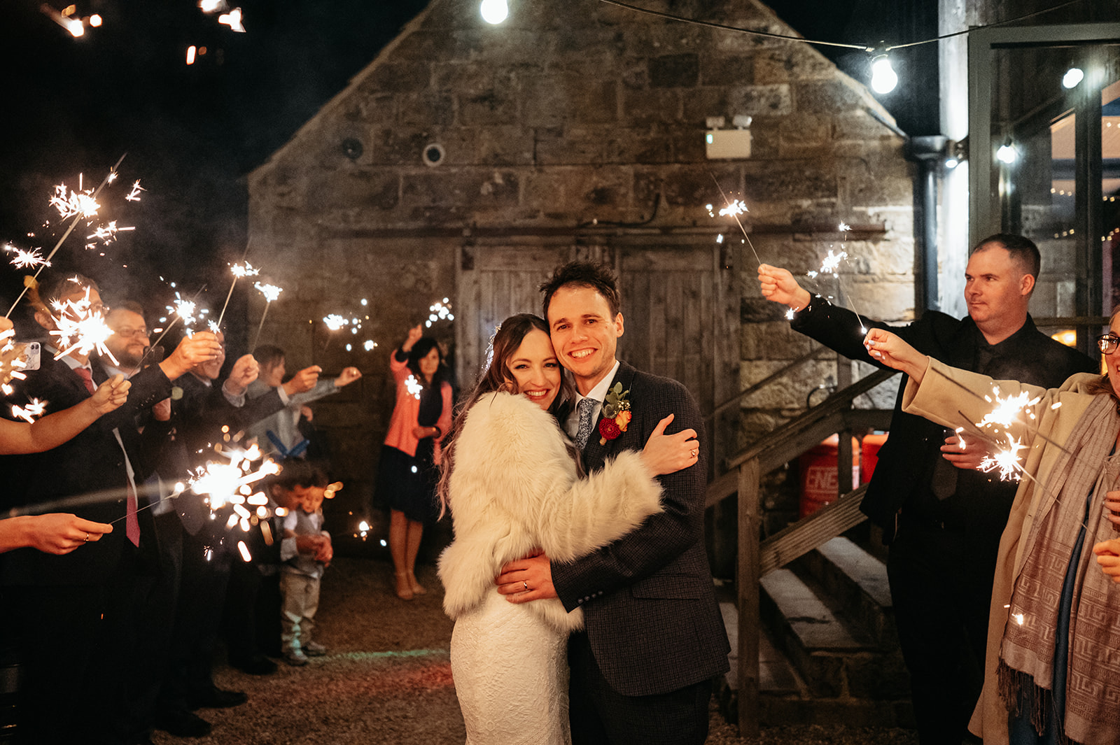 A magical moment captured with Adelle and Ric surrounded by their guests holding sparklers, creating a twinkling light