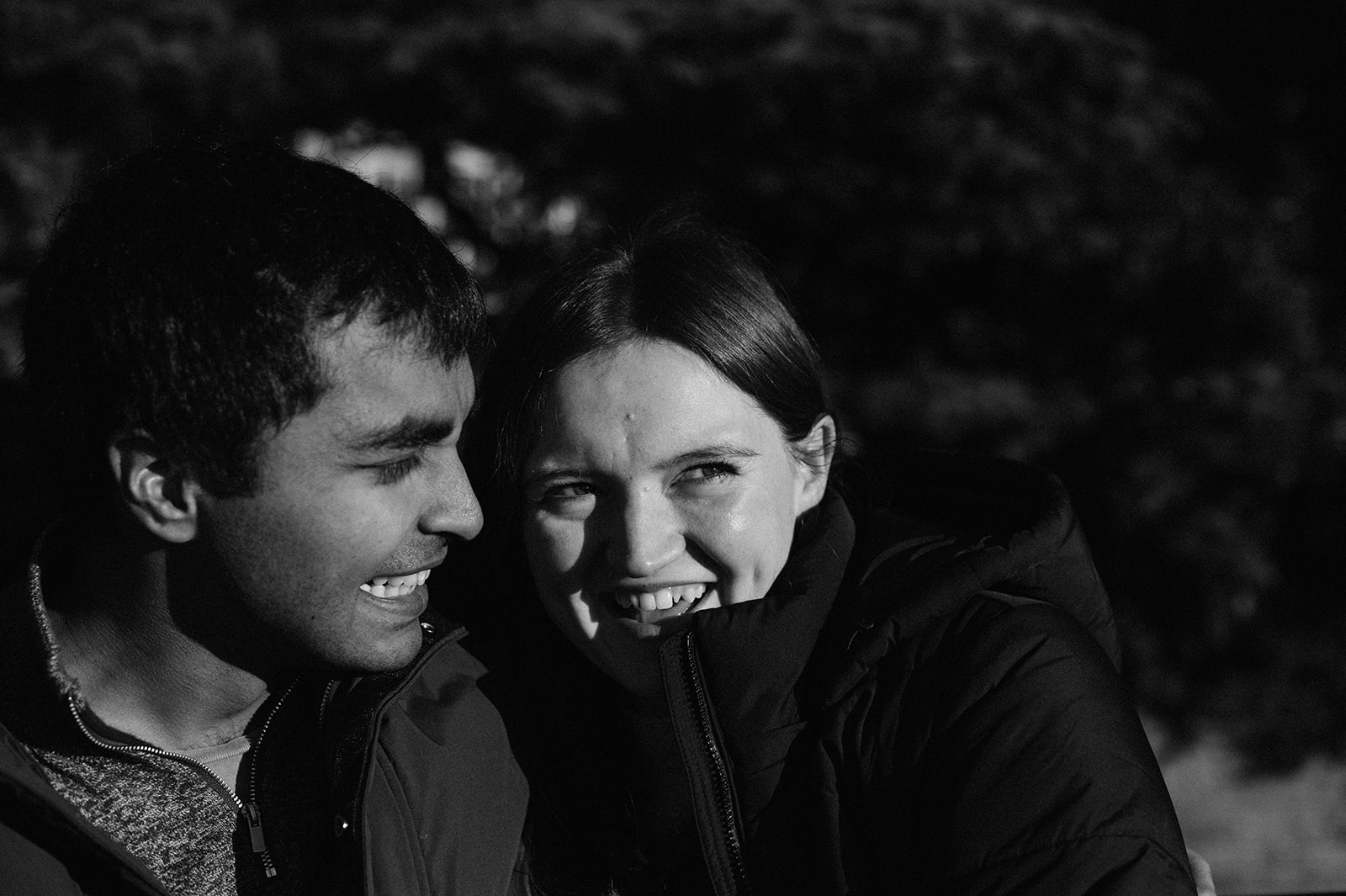 Close up picture in black and white of couple's faces close together smiling.