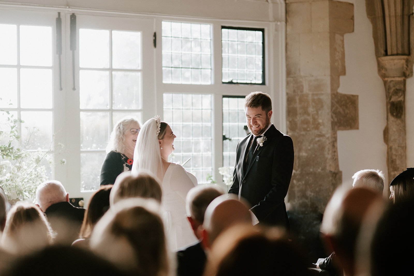 bride and groom exchanging vows in great hall at butley priory