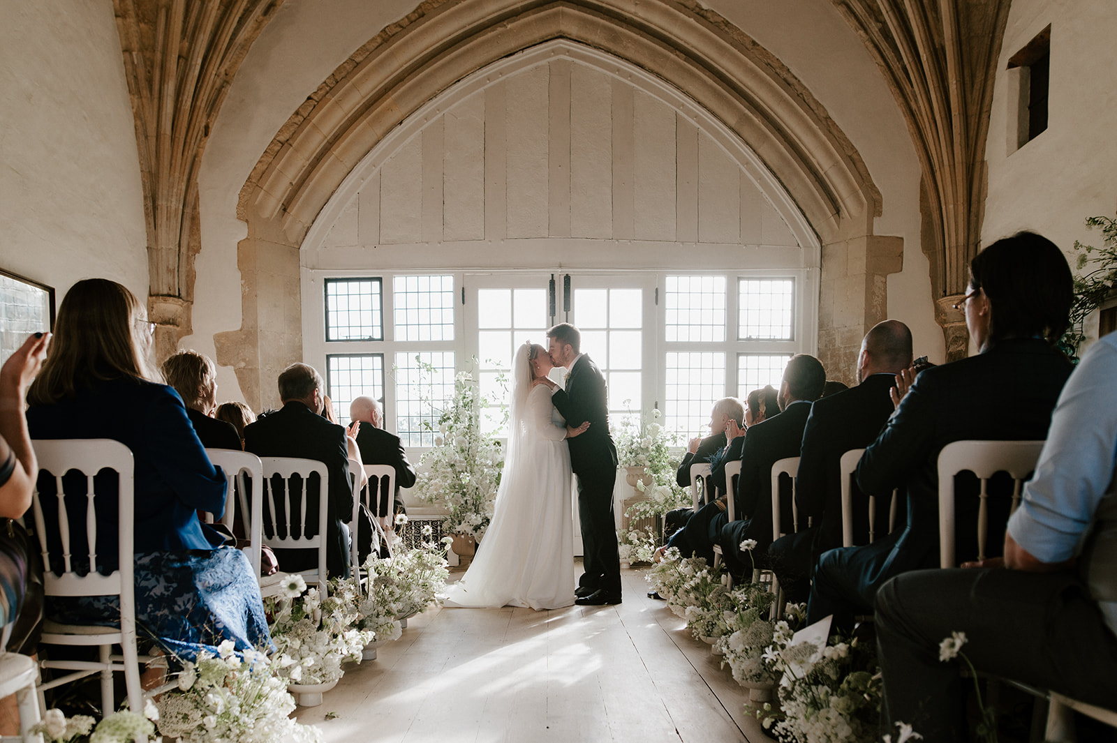 bride and groom first kiss in great hall at butley priory