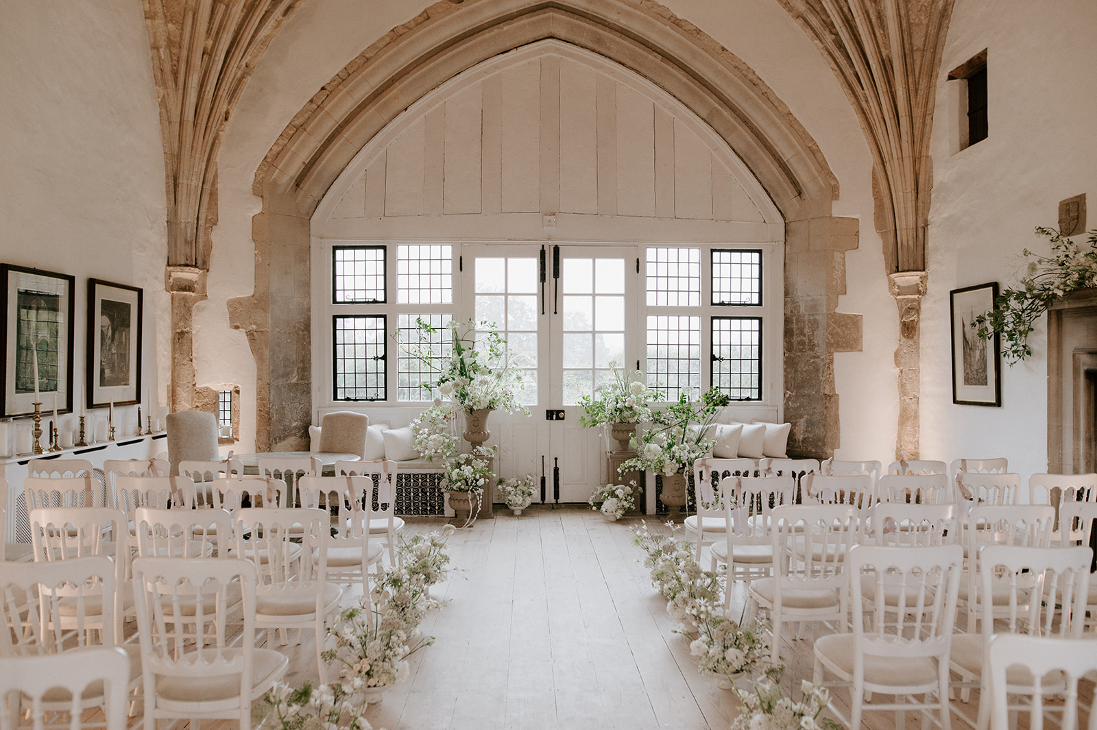 neutral floral ceremony backdrop in great hall at butley priory wedding venue