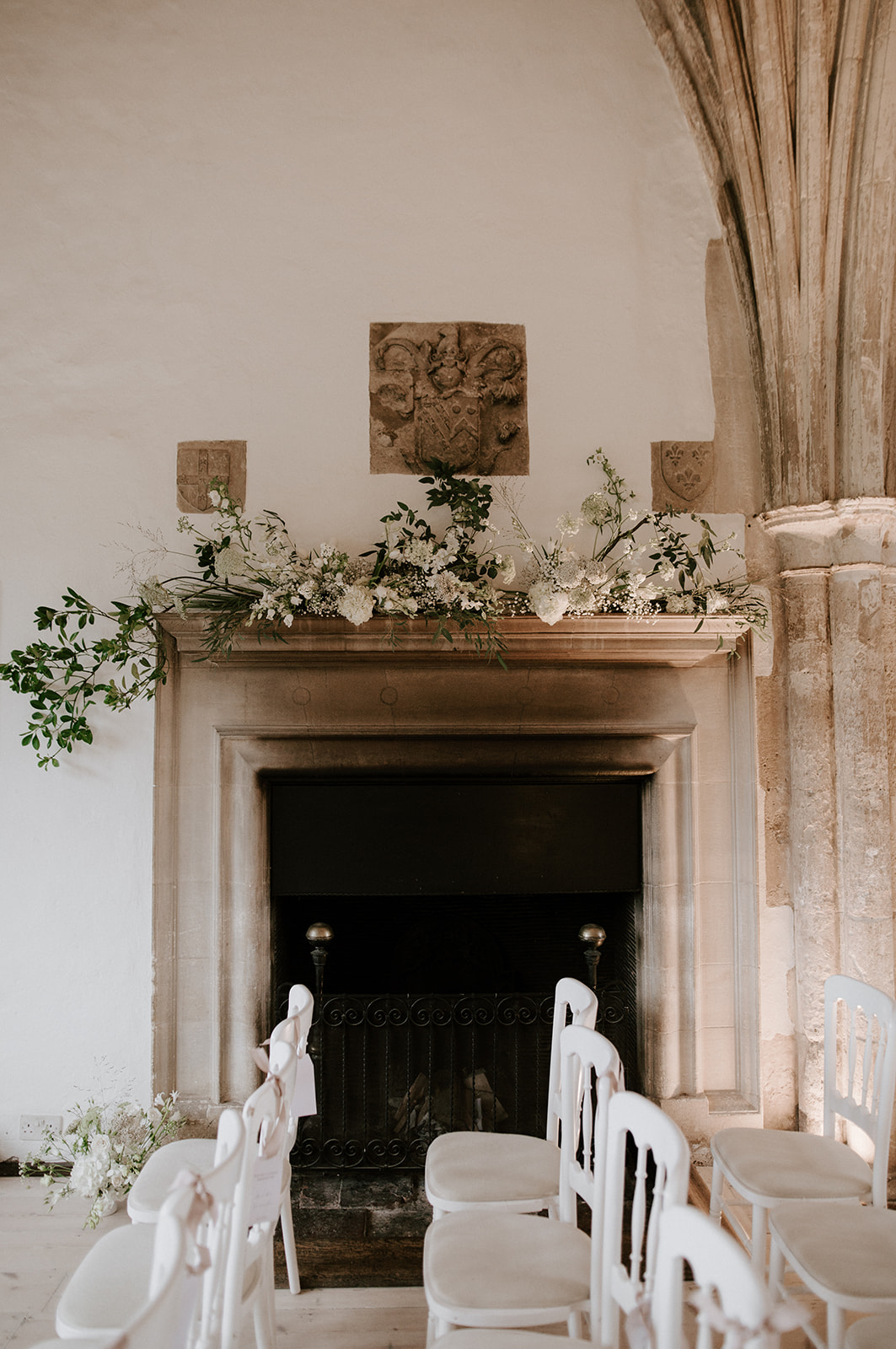 neutral floral mantlepiece in great hall at butley priory wedding venue