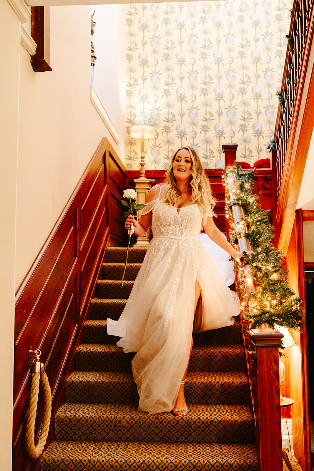 bride walks down stairs at raemoir house