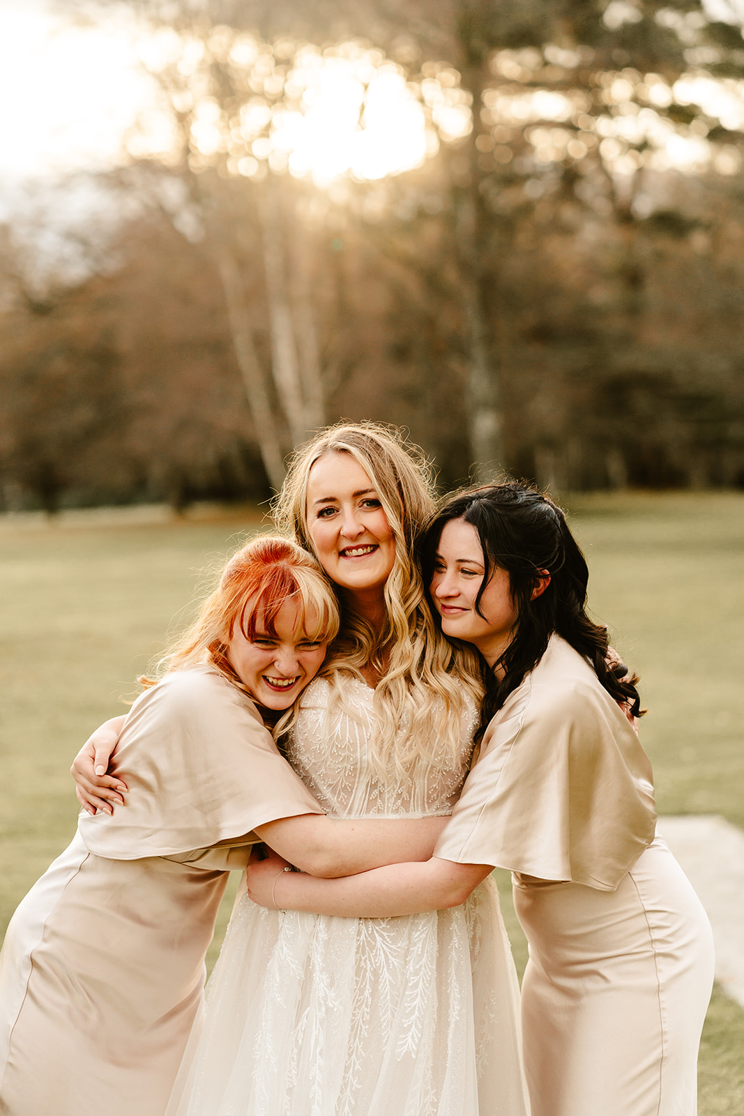 bride cuddles bridesmaids for photo