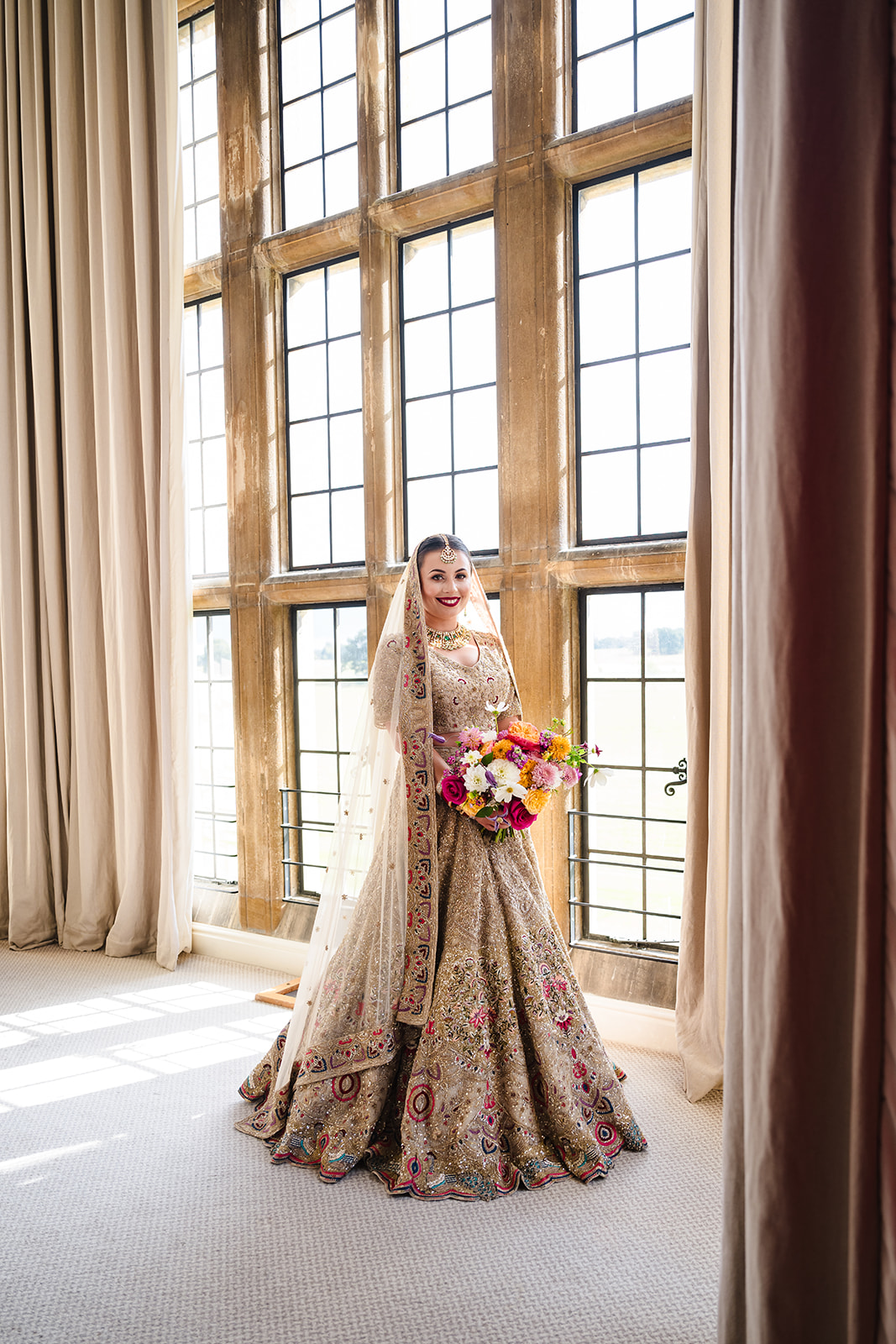 Indian Summer wedding at Stapleford park bride in her dress portrait in thebridal suite by Amanda Forman Photography