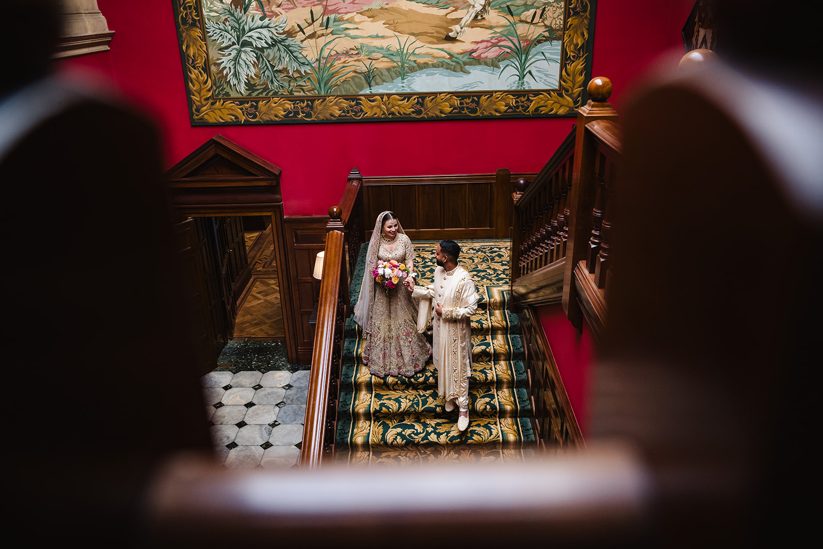 Bride and groom walking down the staircase at Stapleford park hotel an Indian Summer wedding photoshoot by Amanda Forman
