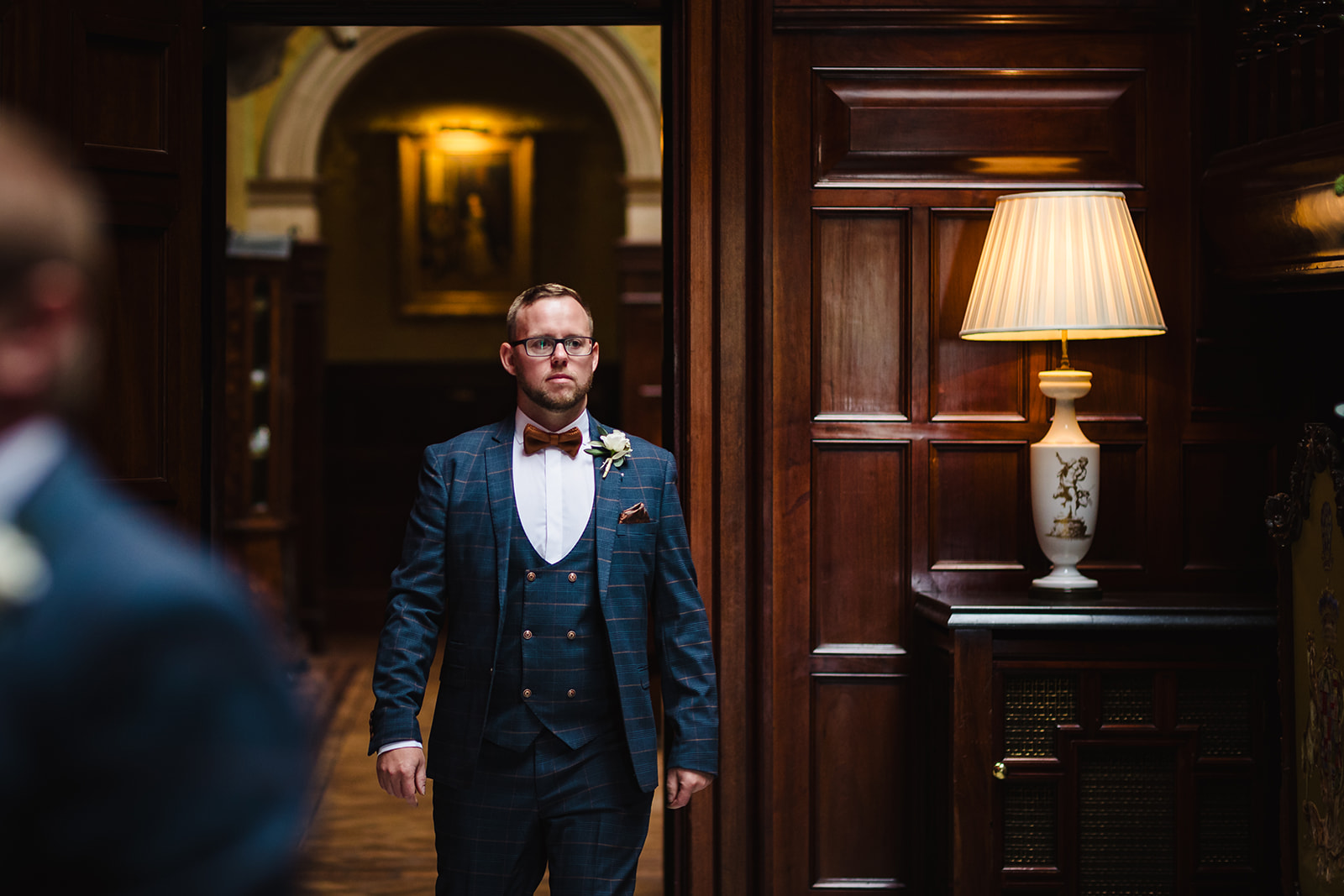 Groom stood at the bottom of the stairs at stapleford park by Amanda Forman Photography