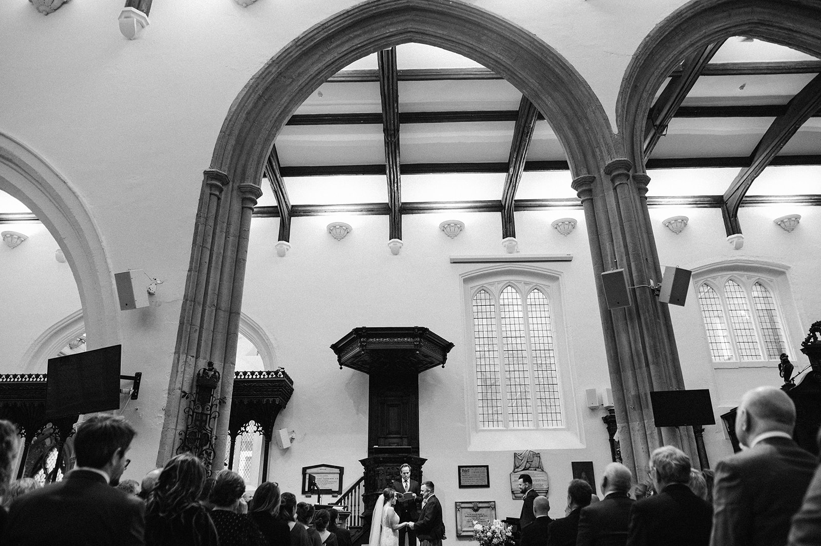 The bride and groom at the front of St Helen's Church Bishopsgate under the huge arches 