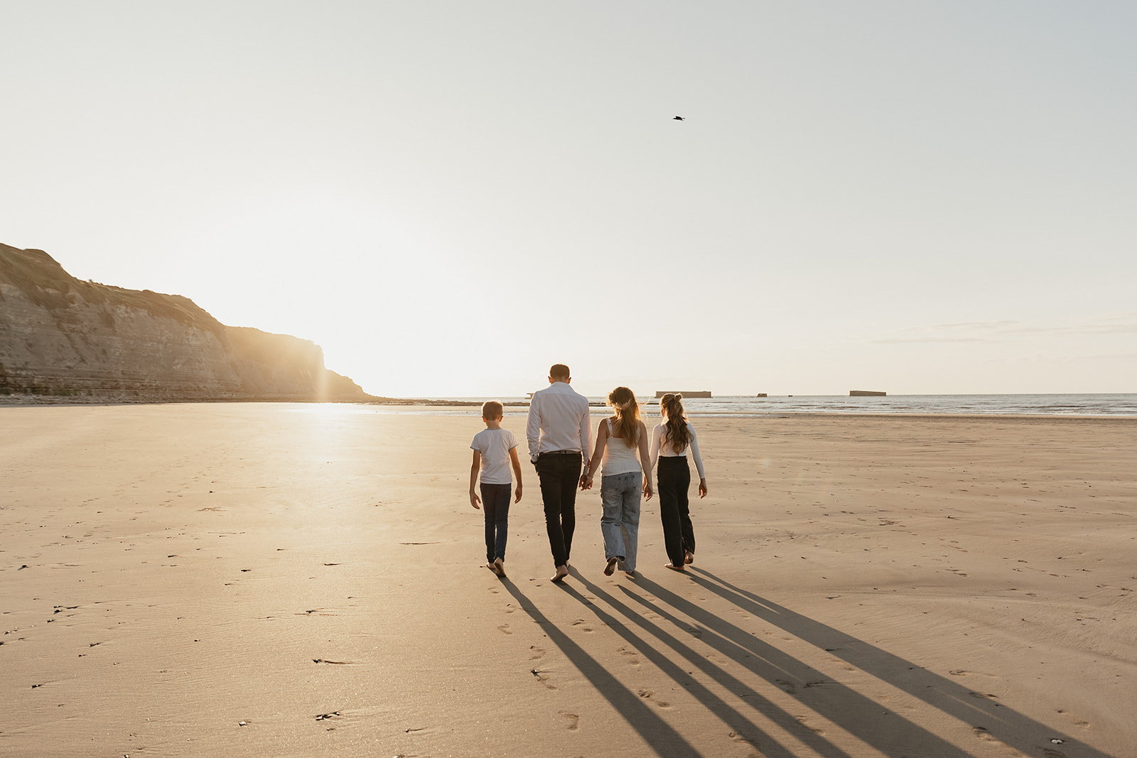 Une famille se fait photographier sur les plages normandes pour célébrer la grossesse de maman. 