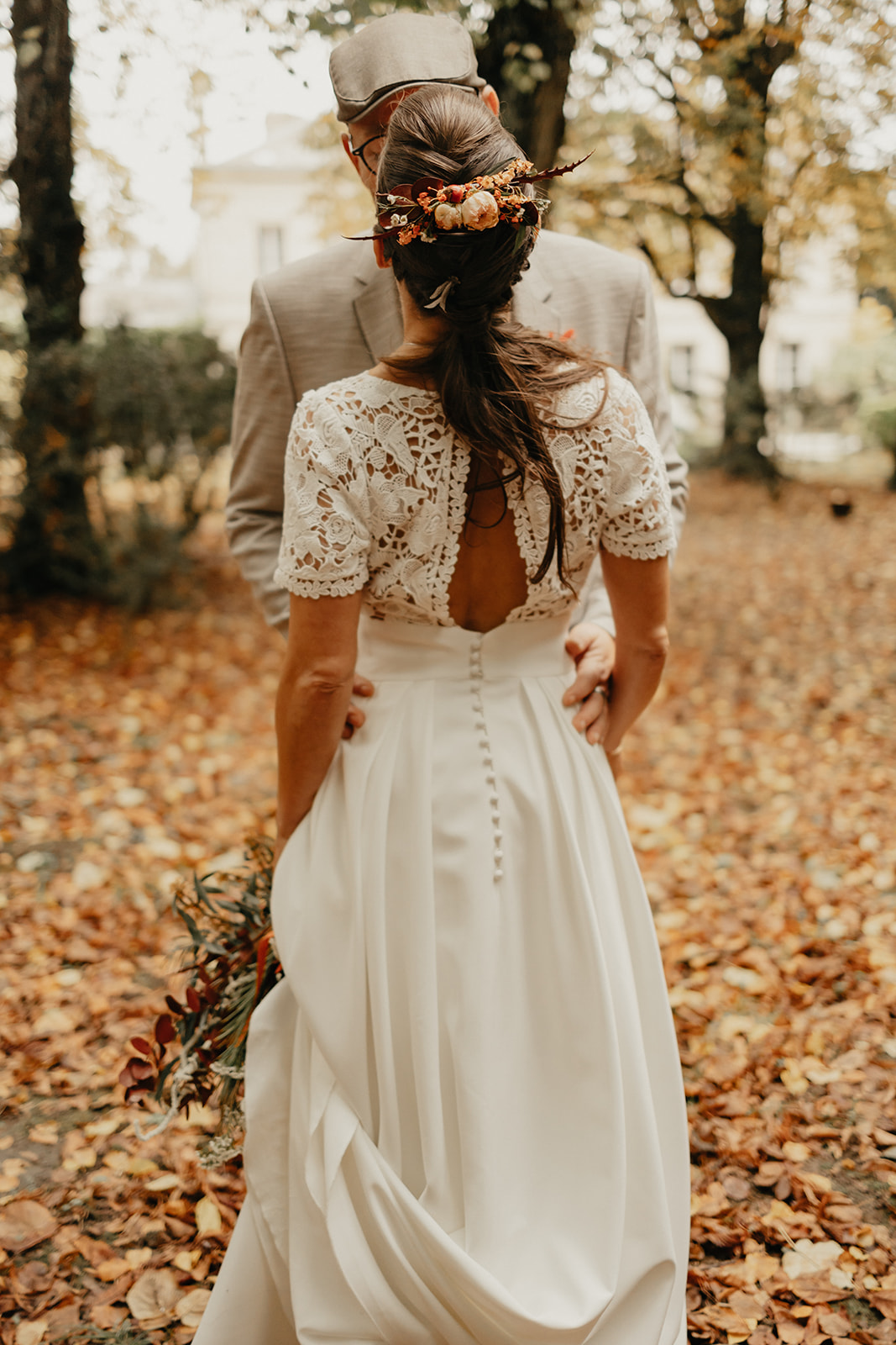 Des mariés se font photographier dans une forêt en automne en Normandie. 