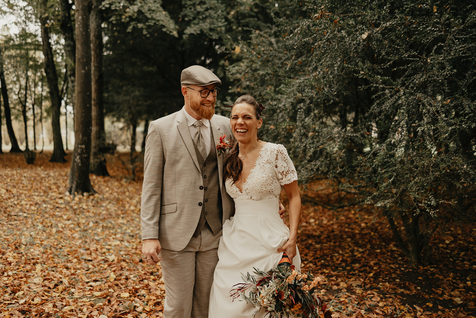 Des mariés se font photographier dans une forêt en automne en Normandie. 