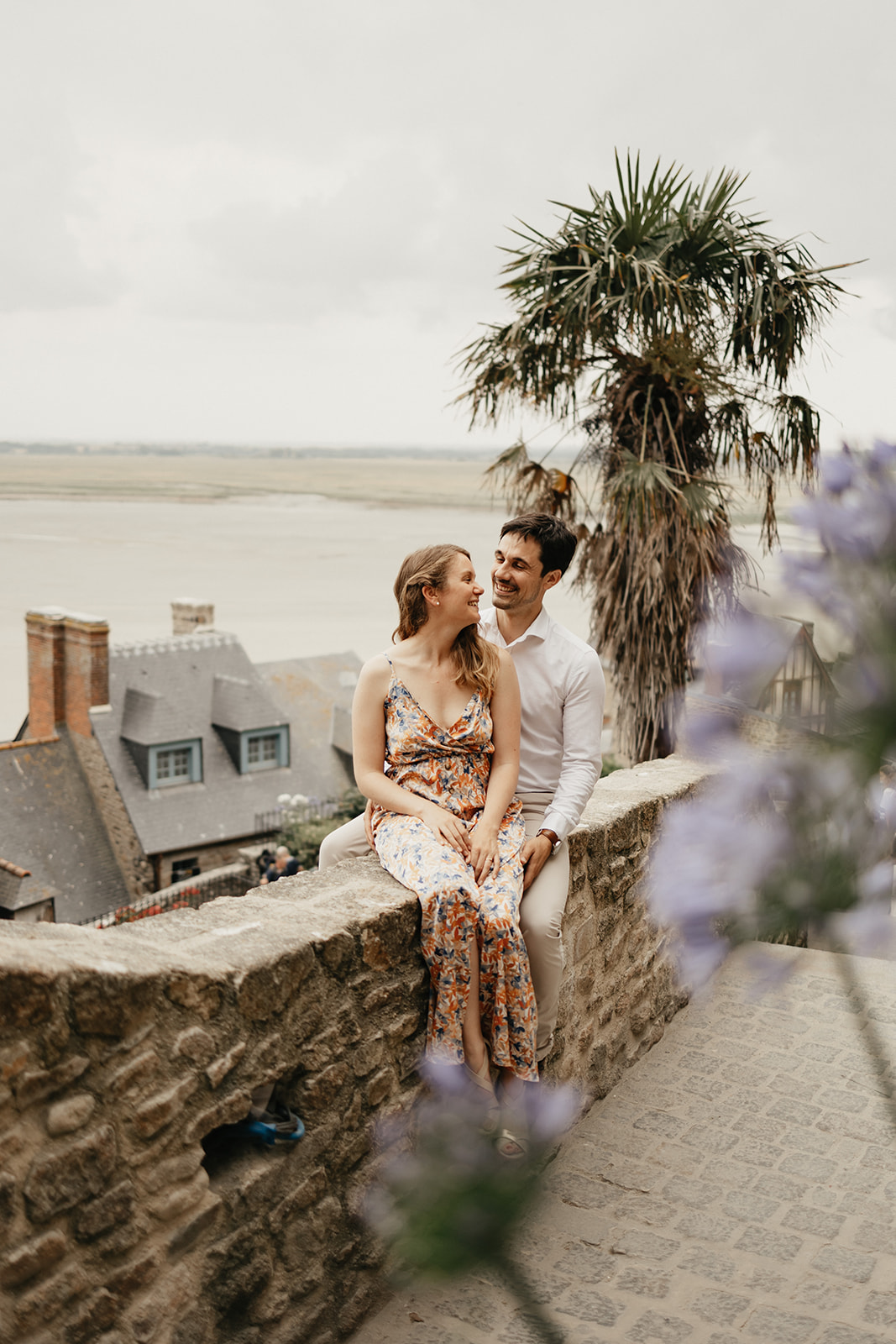 Un jeune couple se fait photographier au Mont Saint Michel en Normandie quelques mois avant leur mariage.