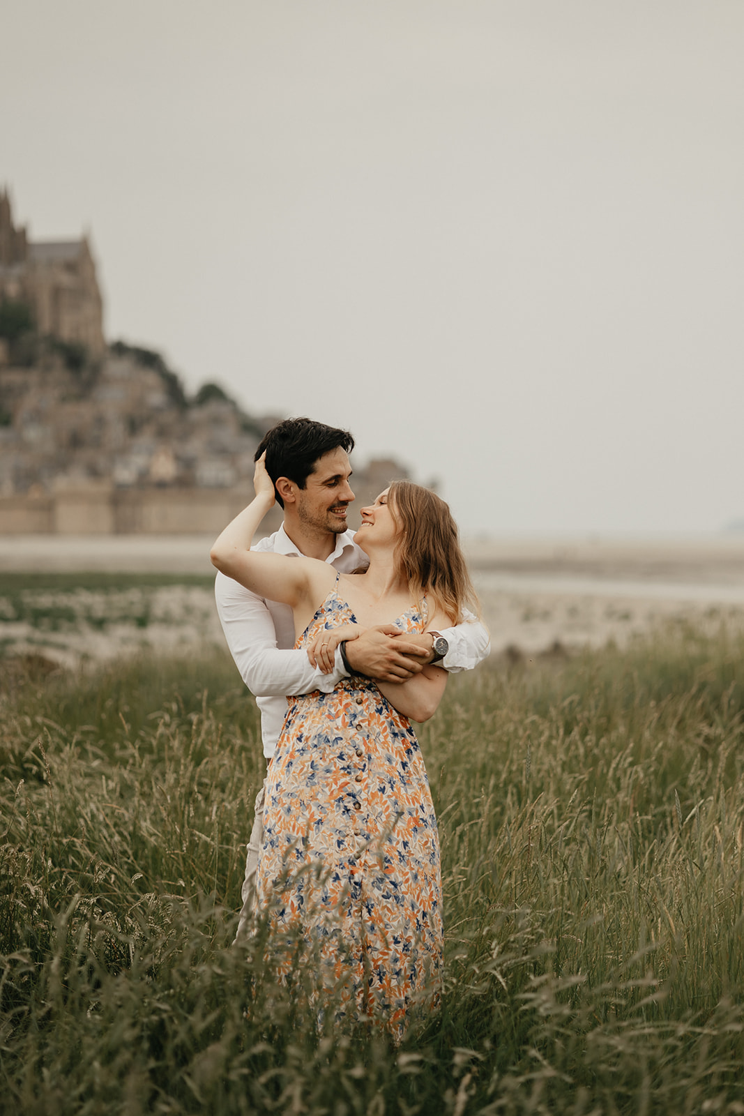 Un jeune couple se fait photographier au Mont Saint Michel en Normandie quelques mois avant leur mariage.