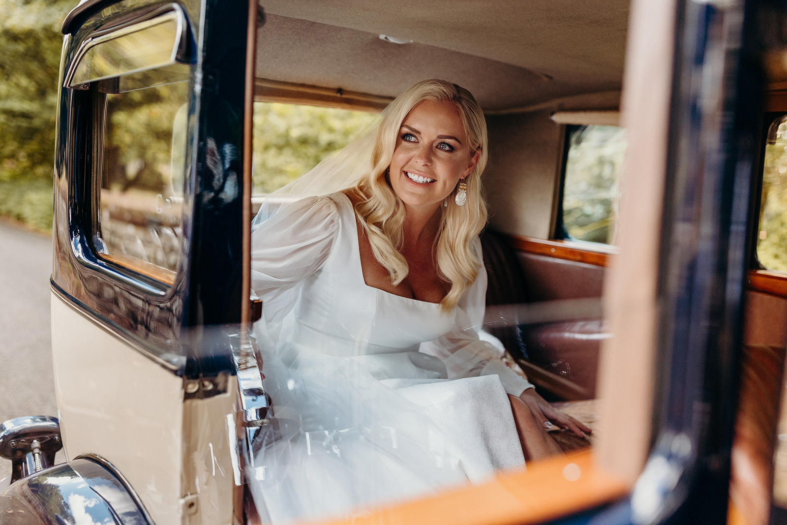 bride looks out of window of vintage wedding car