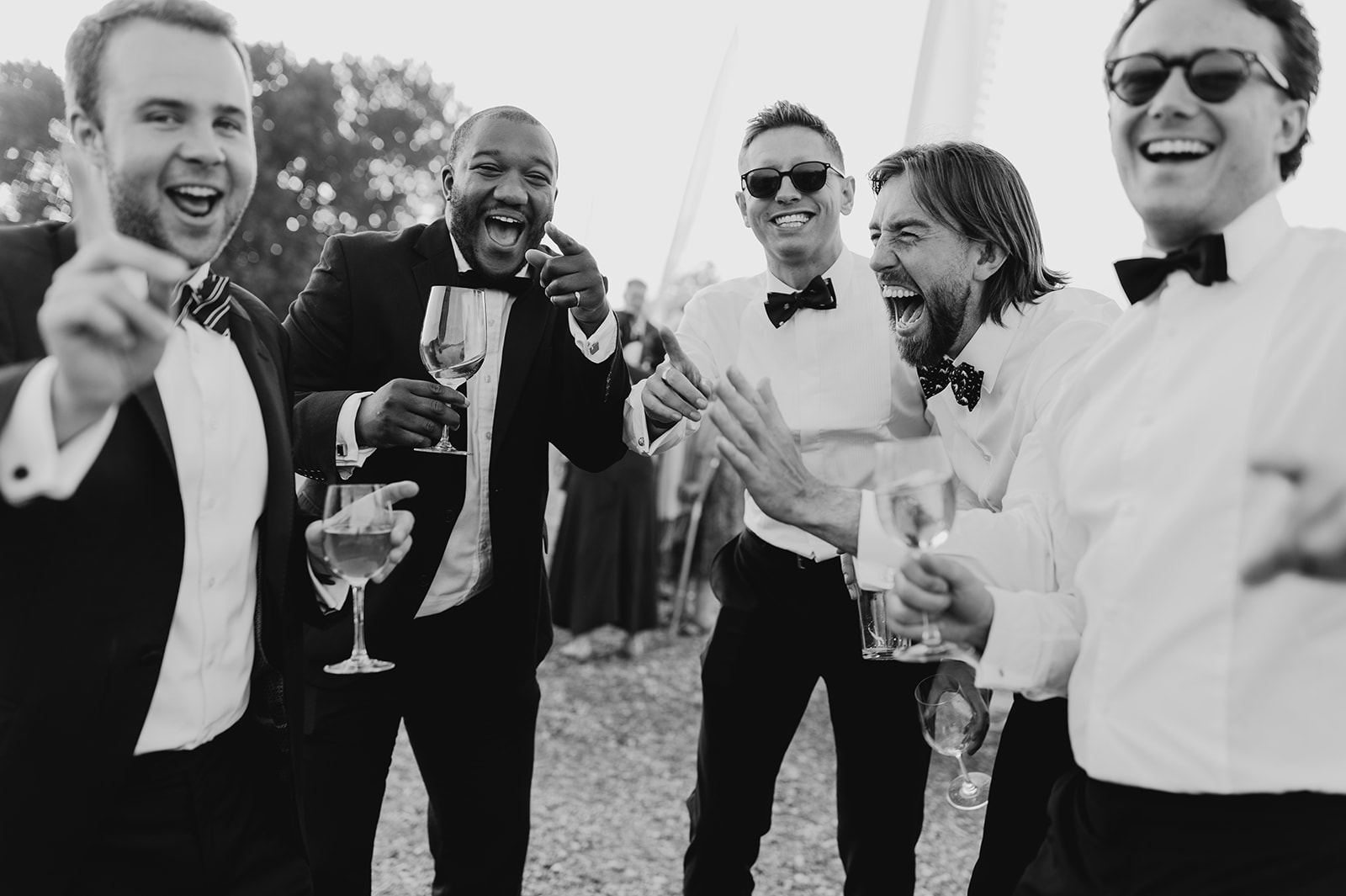 guys laugh and smile as they share a story with each other at wedding 