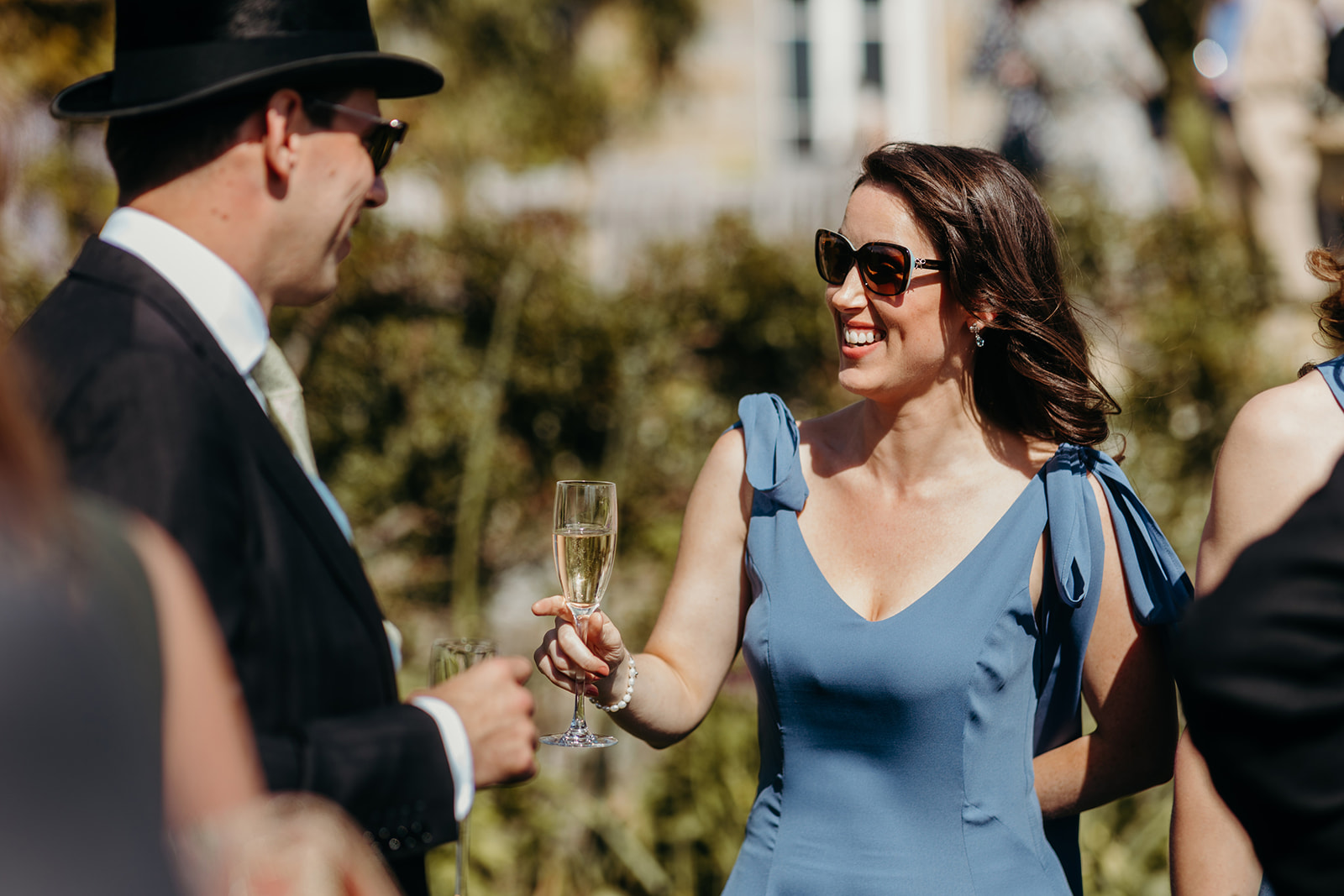 Drinks being savoured amidst laughter in the gardens of the country house wedding venue.